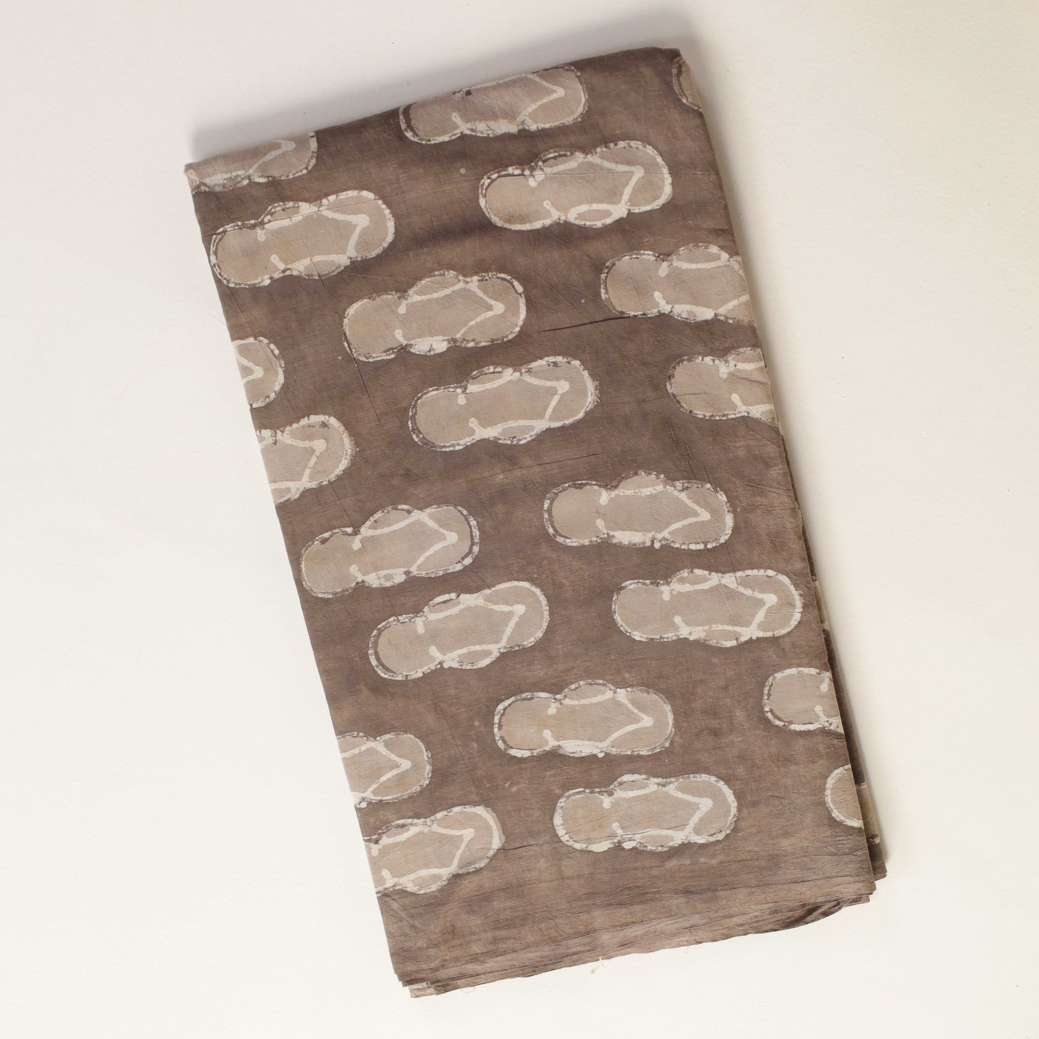 Folded brown fabric with white pattern on a white background