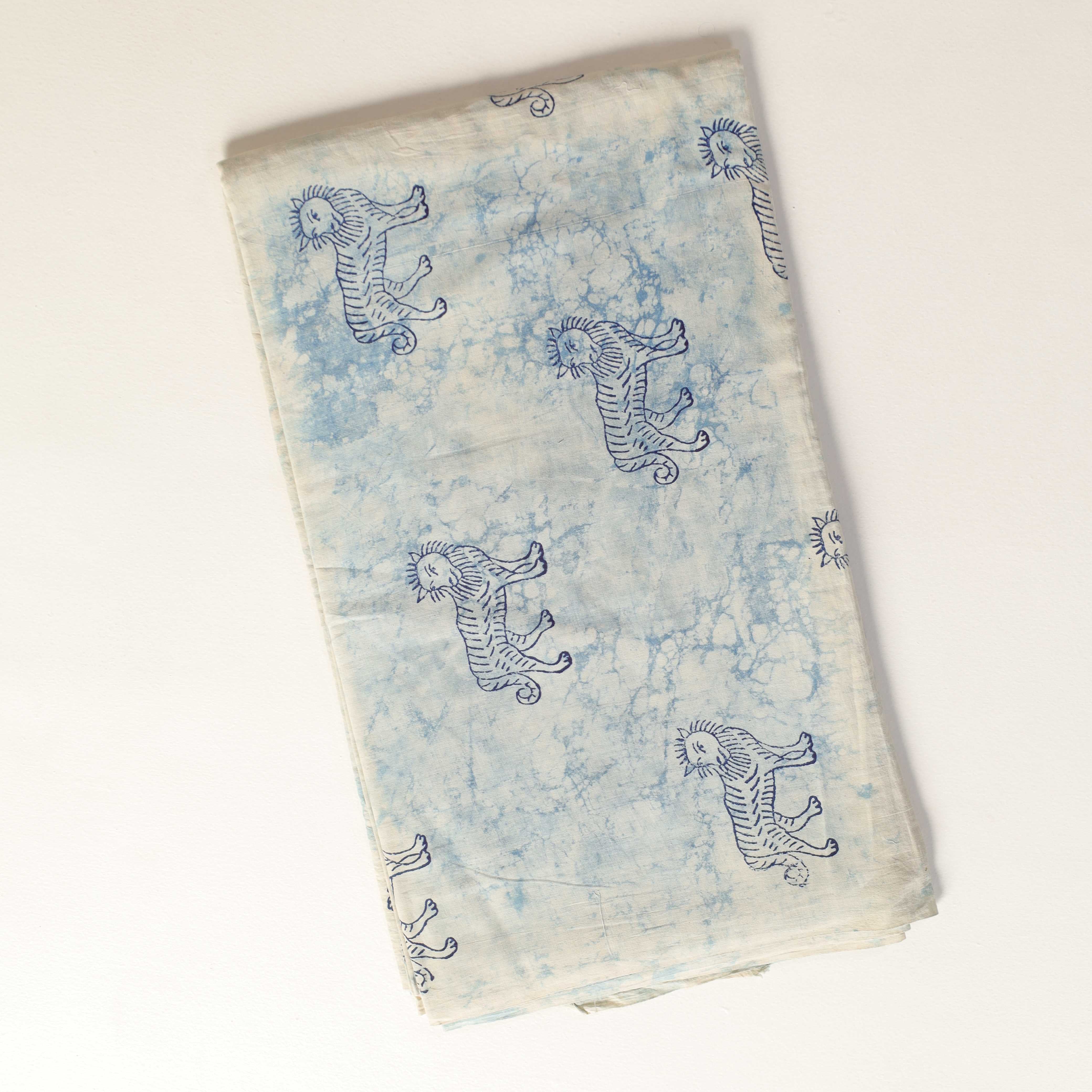 Folded fabric with blue tiger patterns on a light background