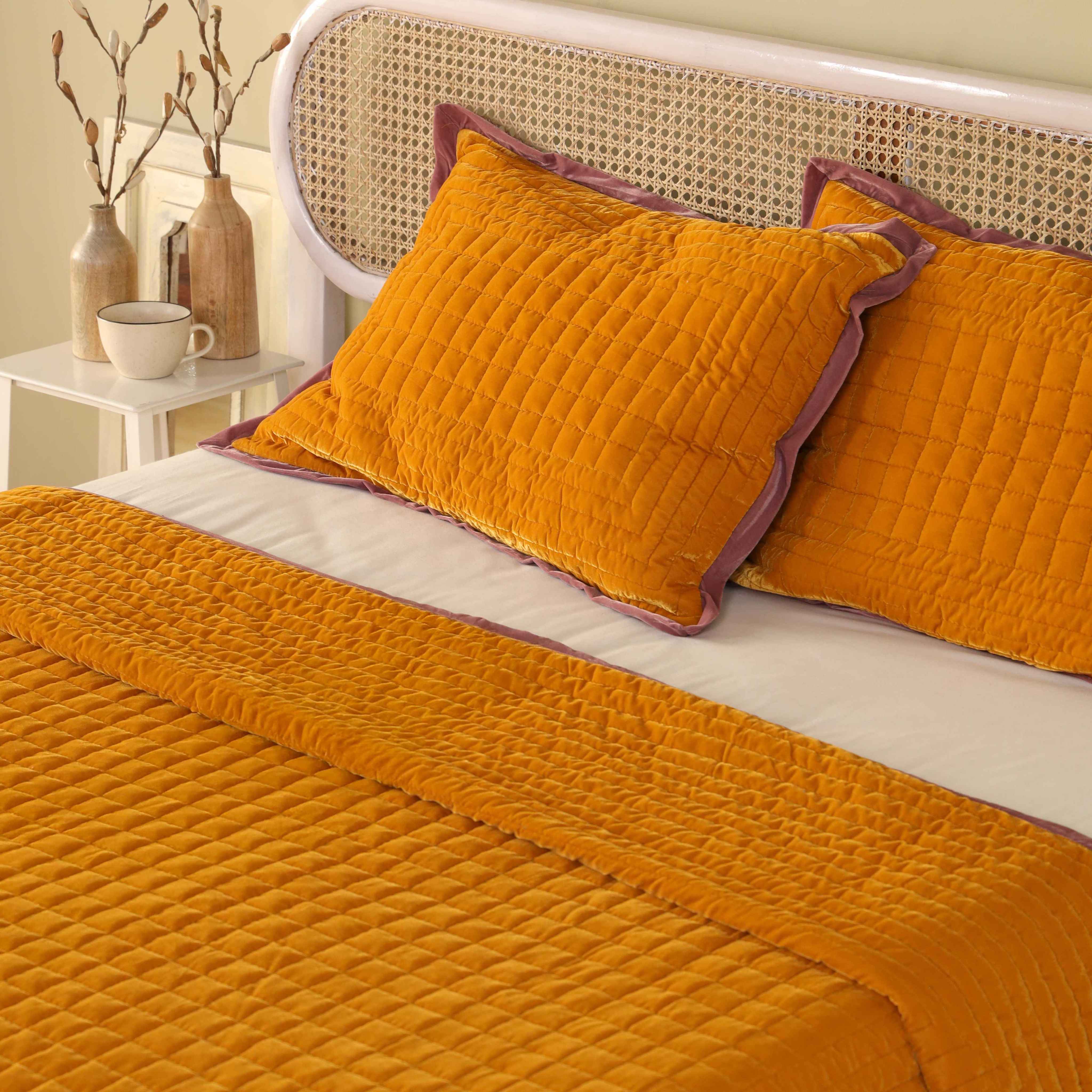 Detailed close-up of the box-stitch quilted texture on soft mustard yellow velvet fabric.