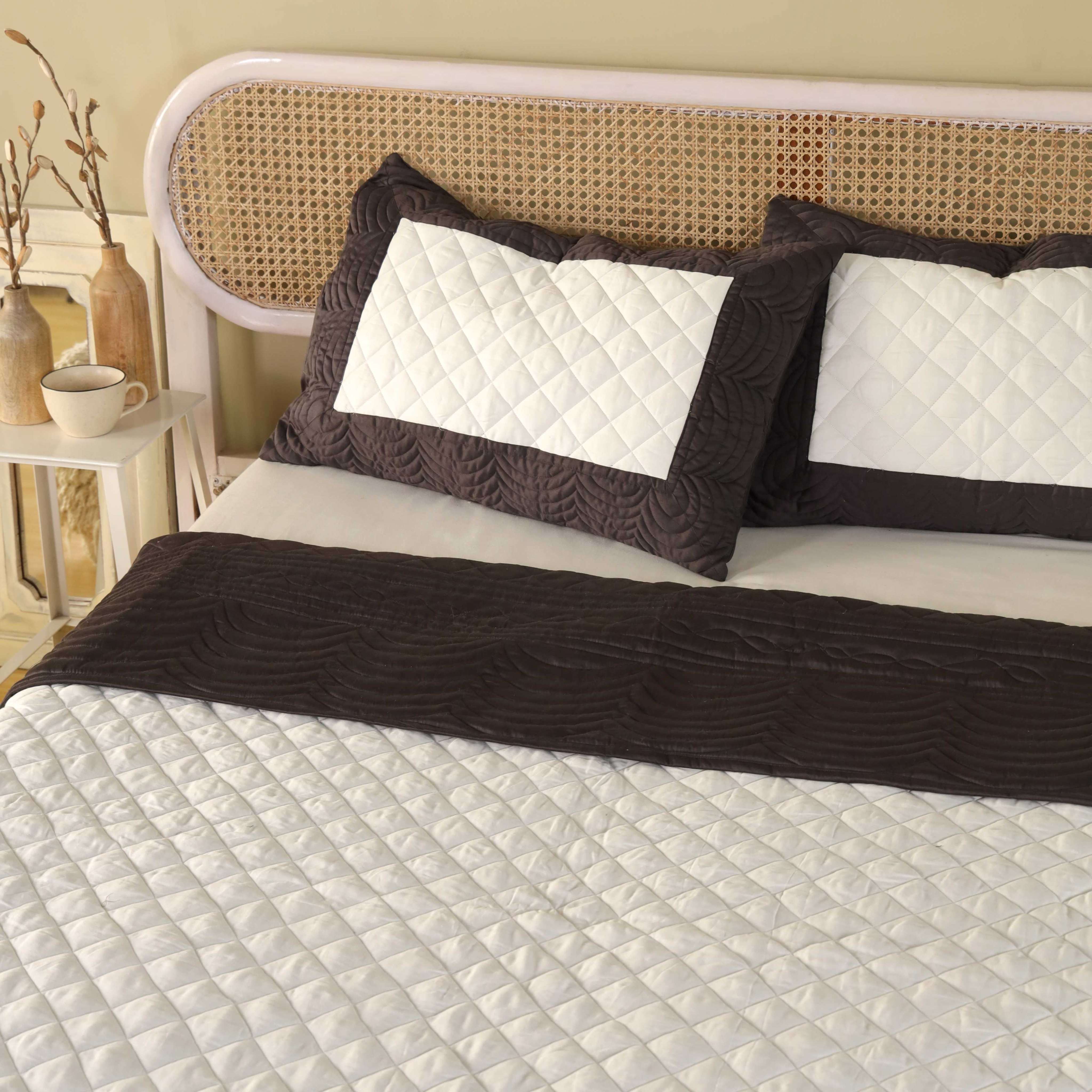 Close-up of the white diamond quilting and chocolate scalloped quilting on satin fabric.