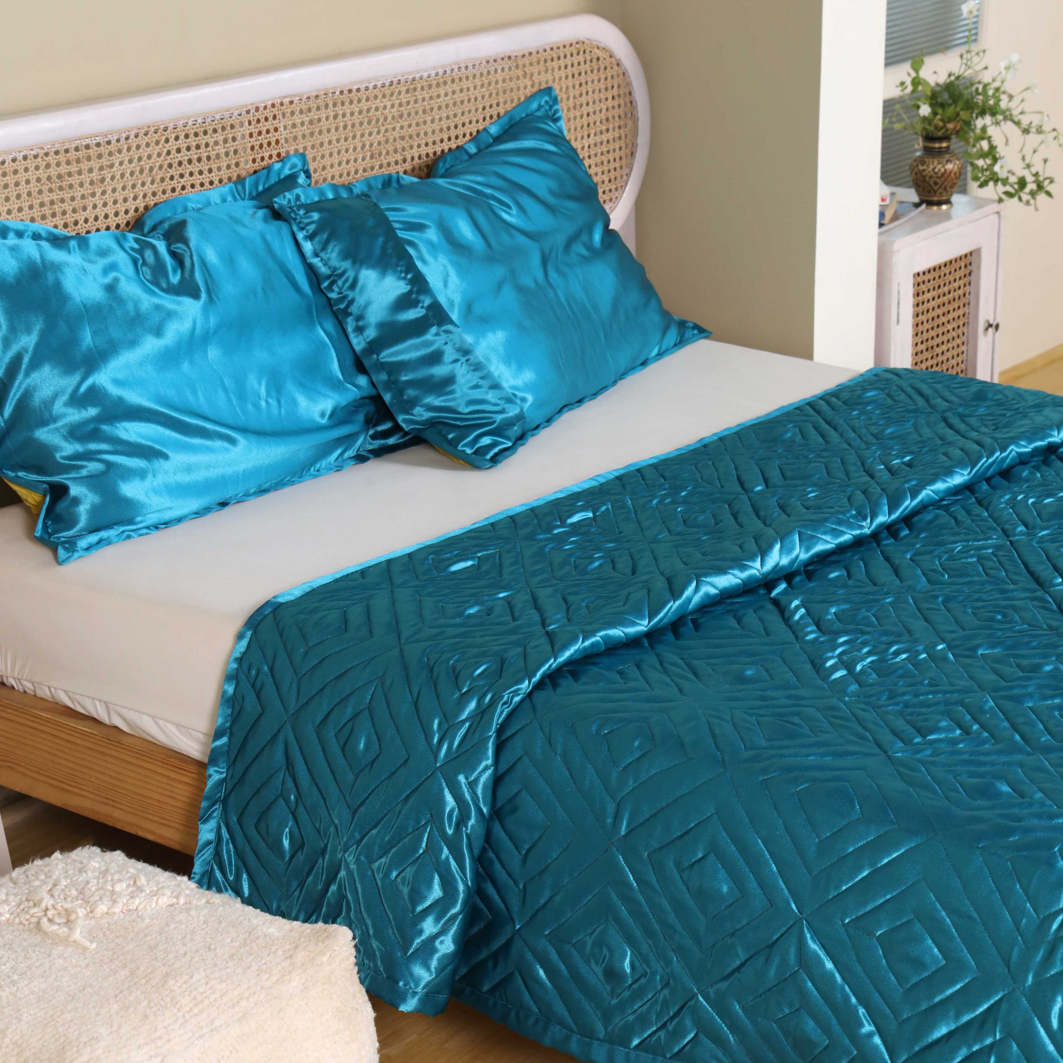 Detailed shot of the quilted geometric pattern on premium teal satin fabric.