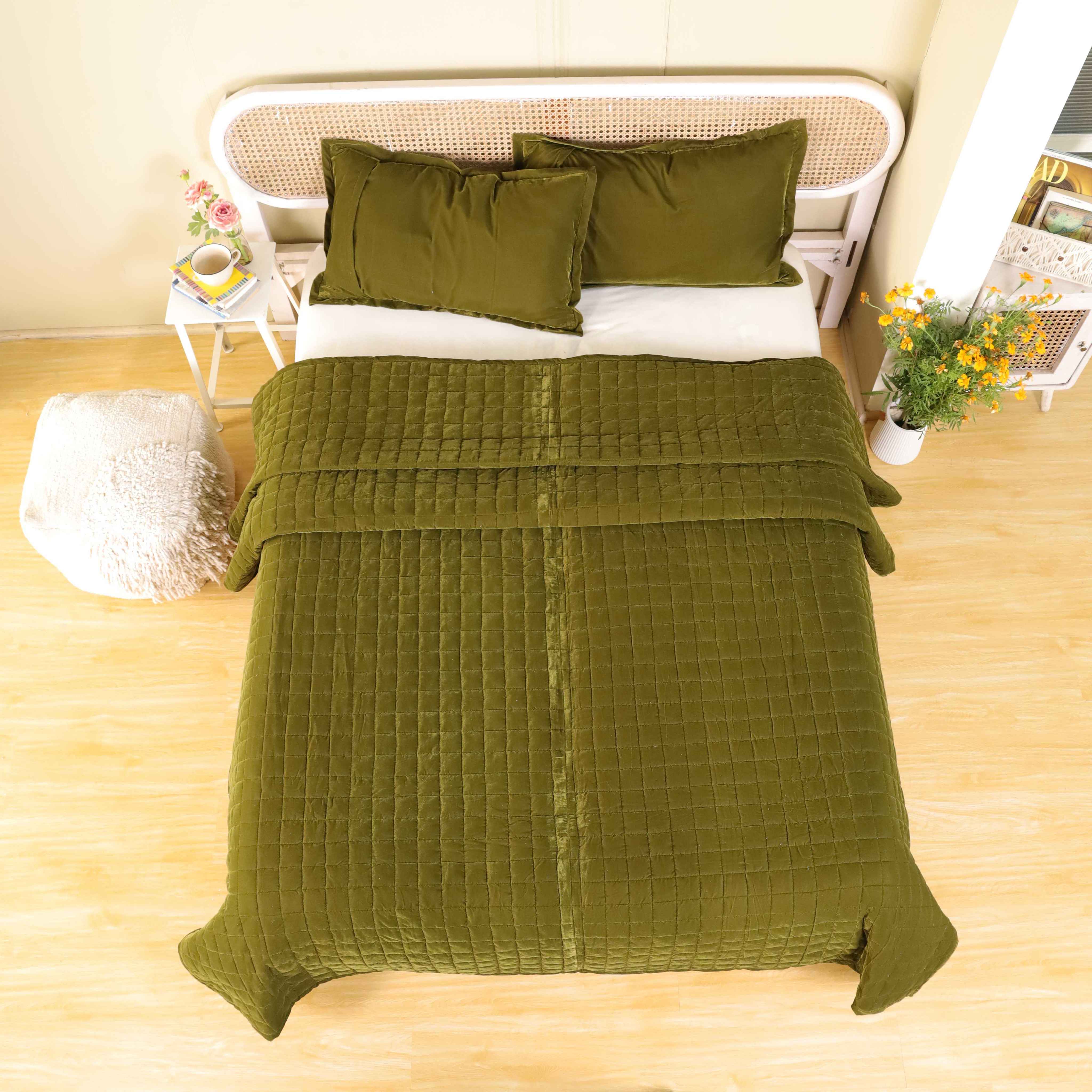 Close-up of plush velvet fabric showing the olive green color and detailed box stitching.