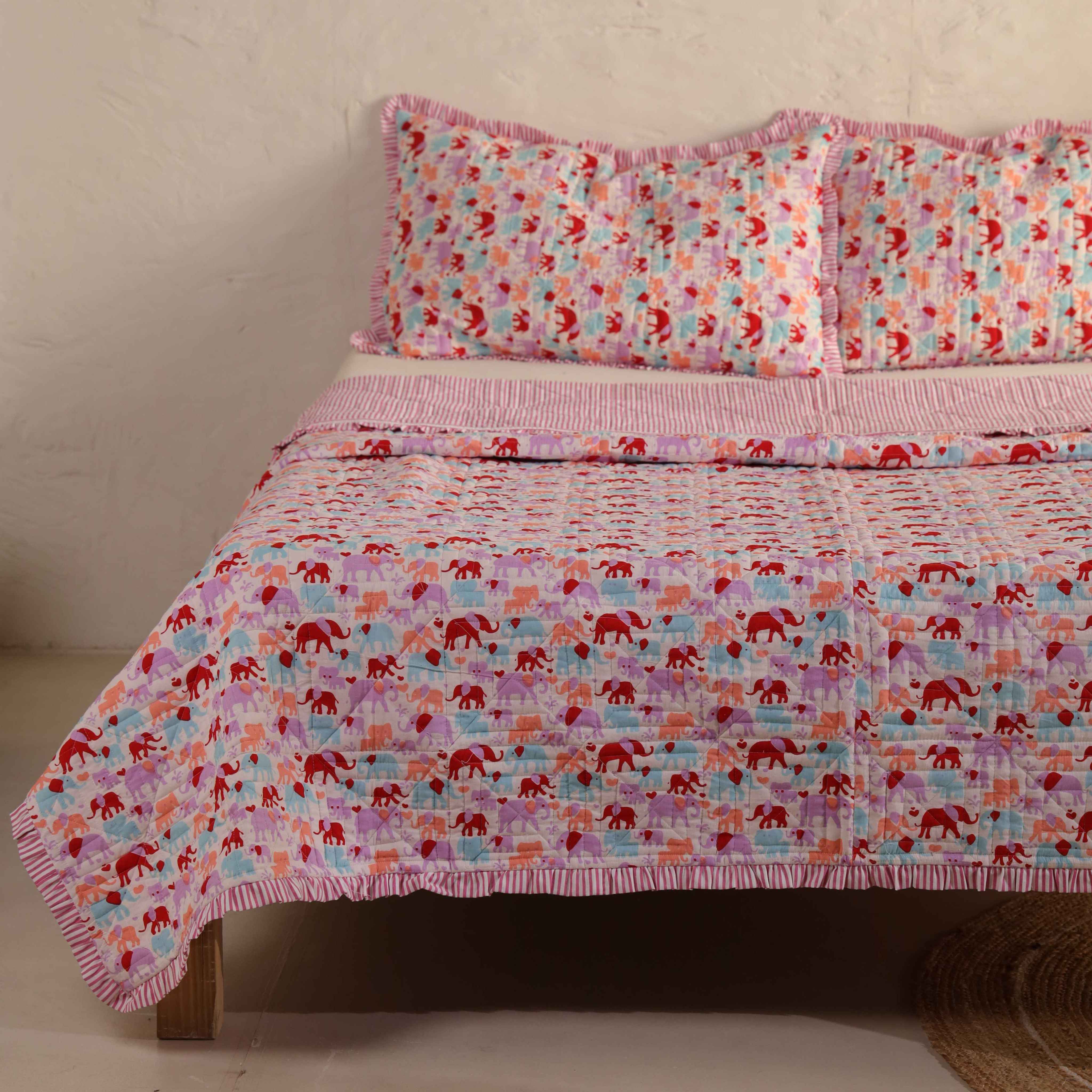 Close-up of the pink striped ruffle trim and elephant motif on a cotton quilt.