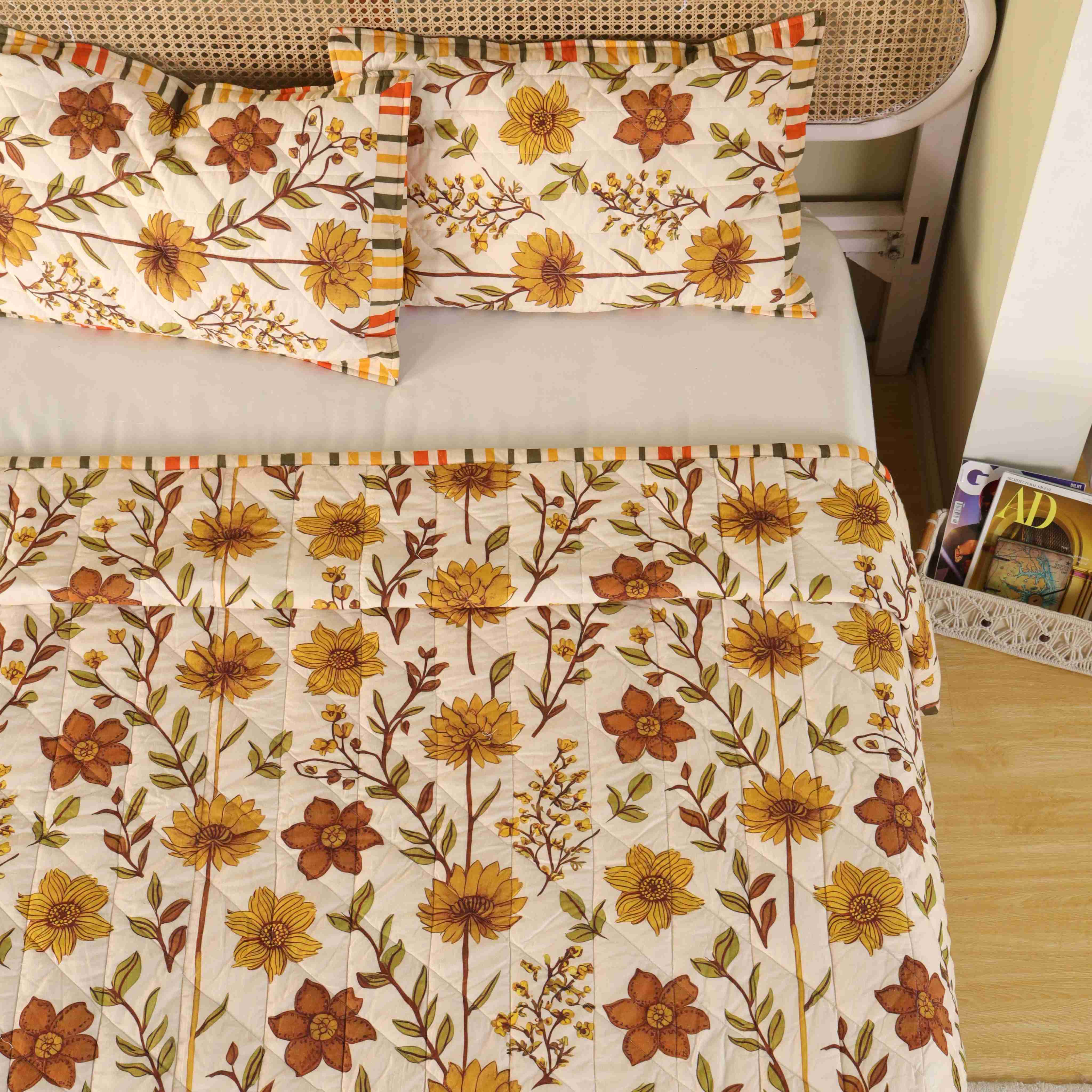 Neatly folded stack of the beige and olive cotton quilt set.