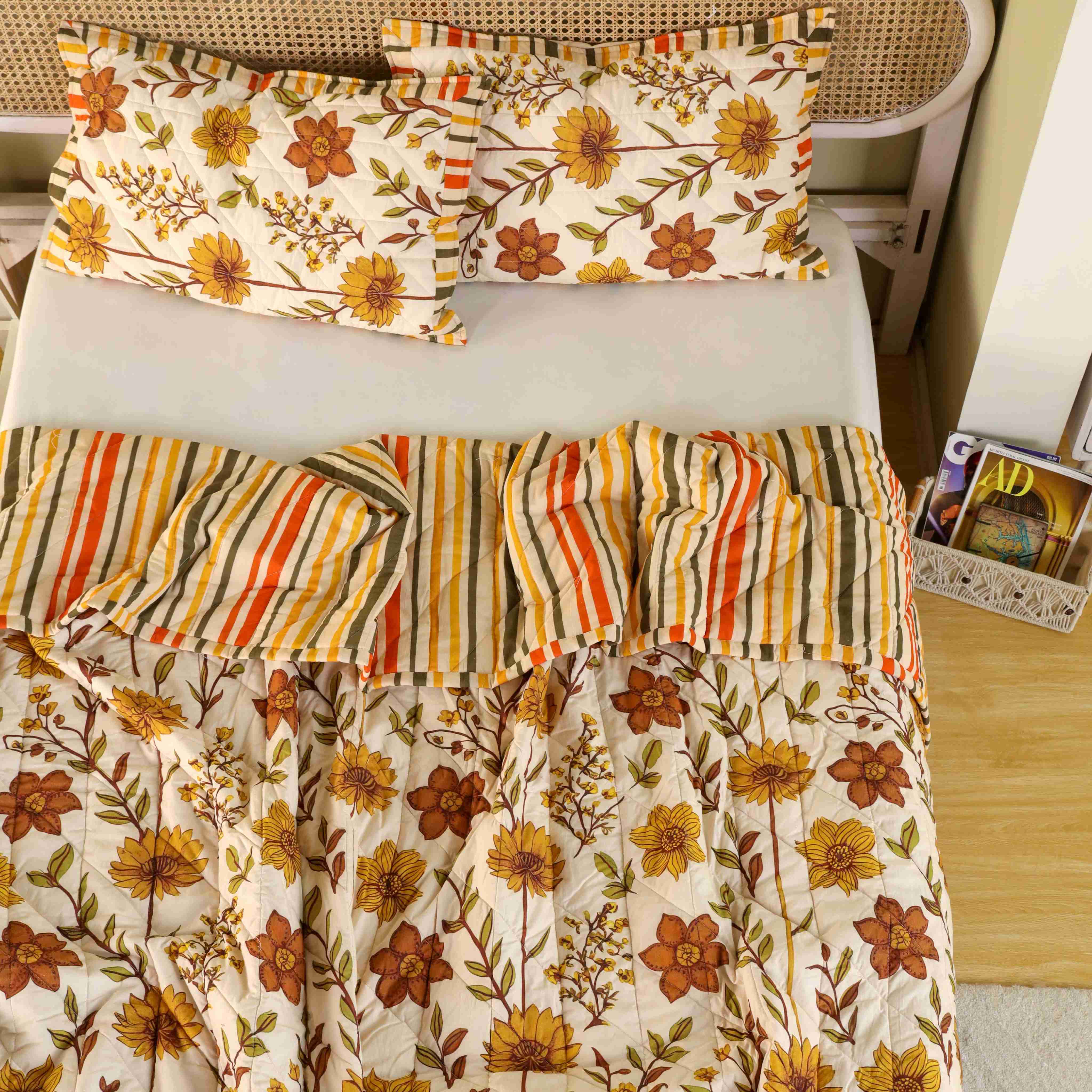 Neatly folded stack of the beige and olive cotton quilt set.