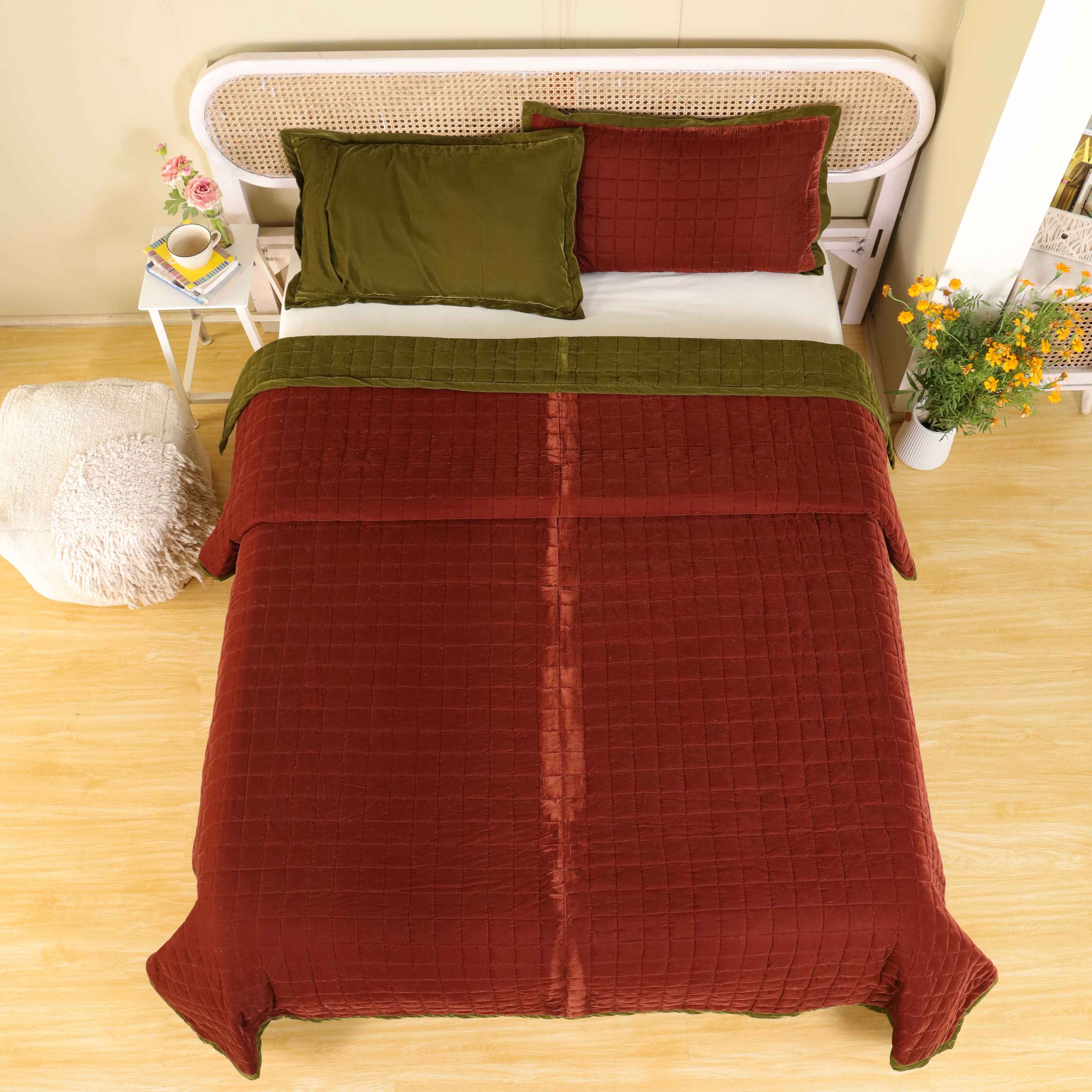 Overhead view of a modern bedroom styled with a reversible earthy-toned velvet quilt.
