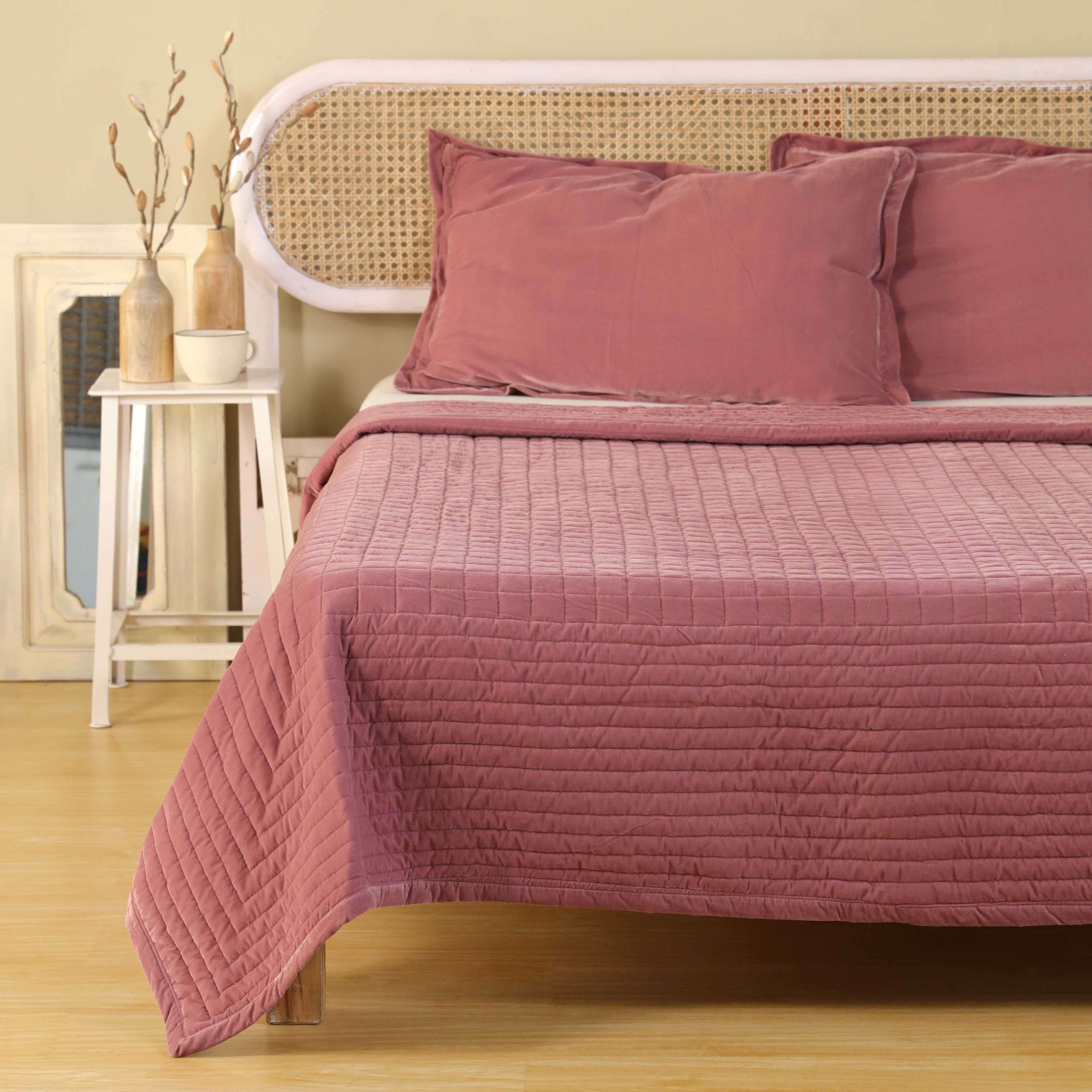 Luxury dusty pink quilted bedding set styled in a bright, minimalist modern bedroom.