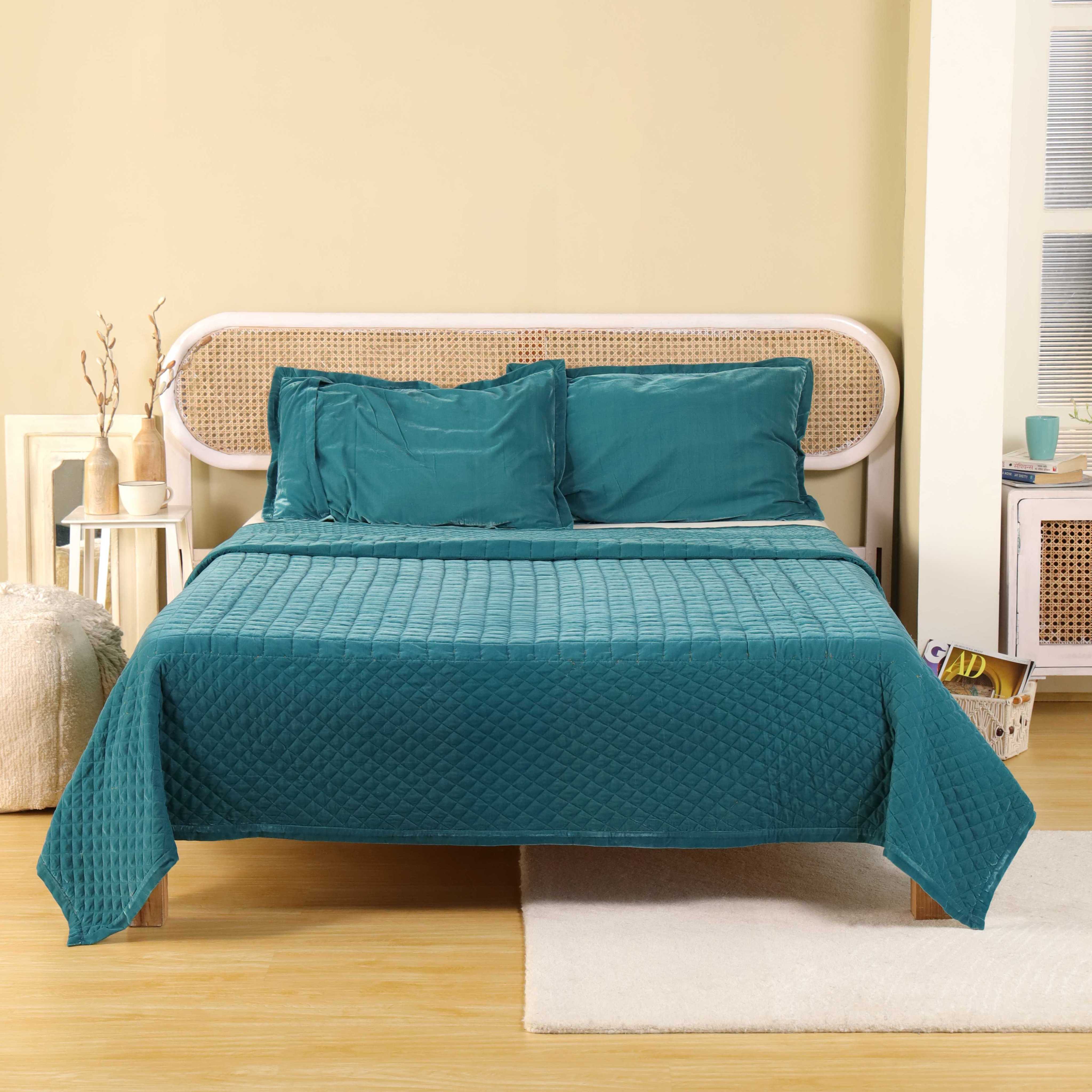 Full view of a luxury teal velvet bedding set in a bright, modern bedroom setting.