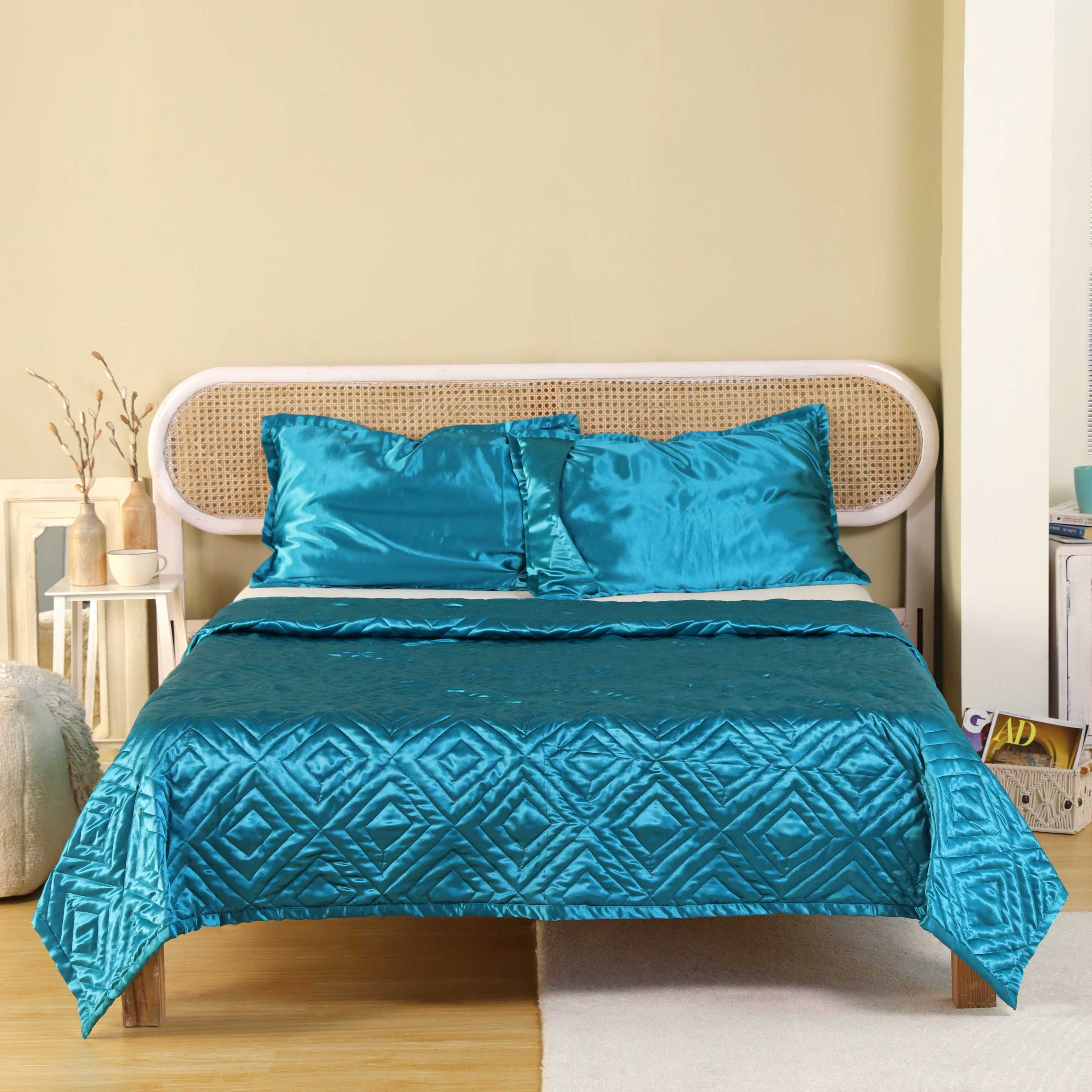 Full view of a luxury teal satin bedding set in a bright, minimalist bedroom setting.