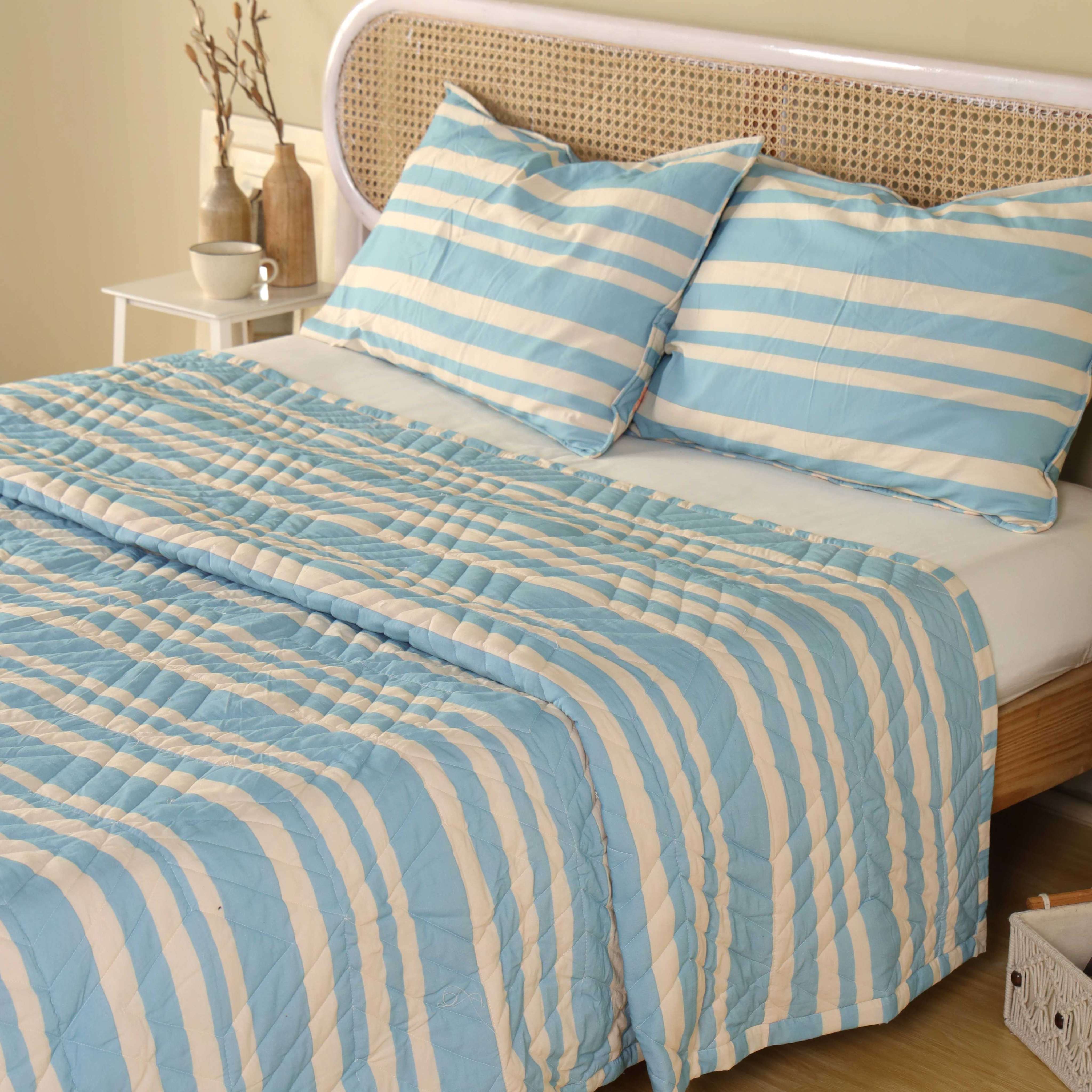 Close-up of the soft velvet texture and striped pattern of the luxury blue quilt.