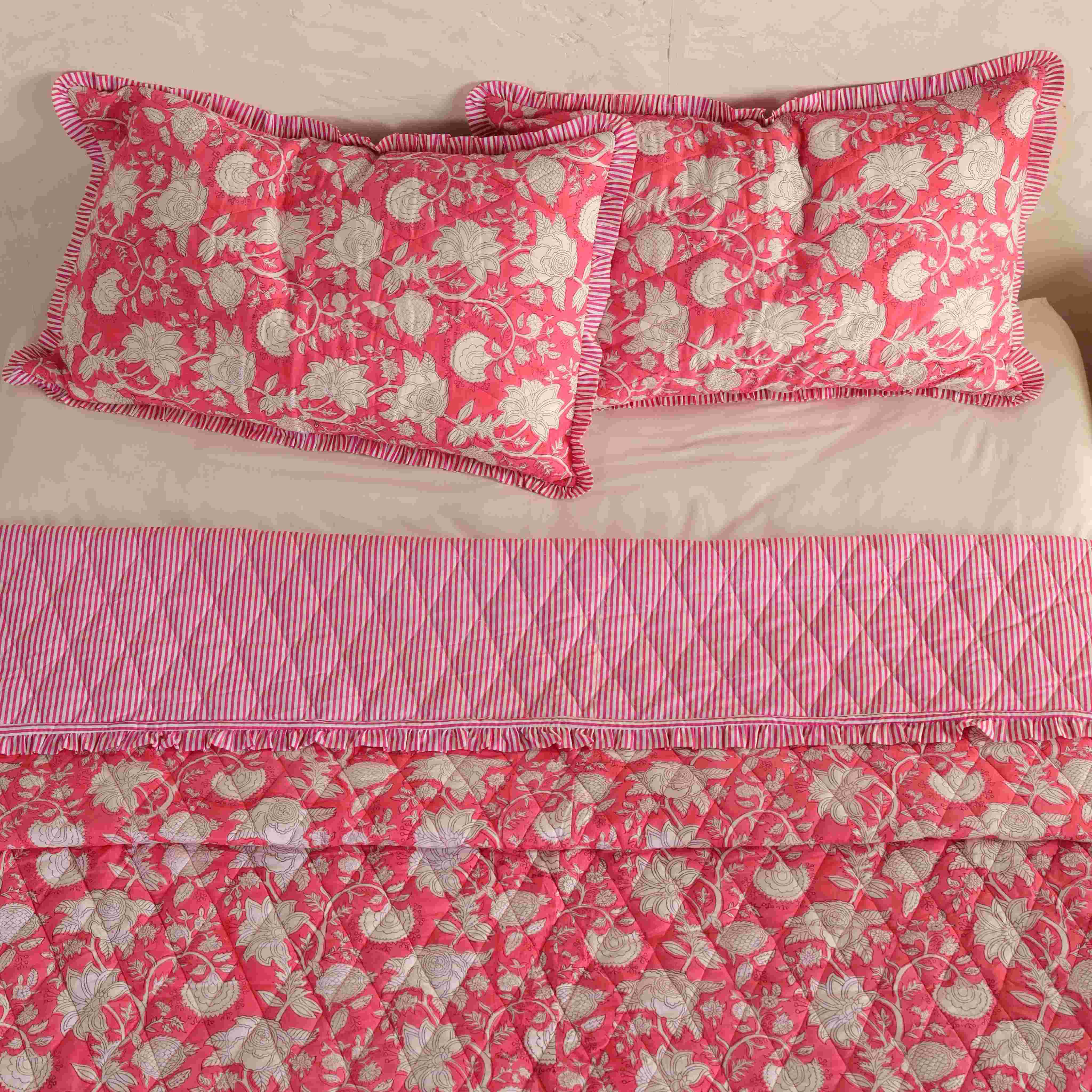 Shabby chic bedroom decor featuring a pink floral quilt and natural wood accents.