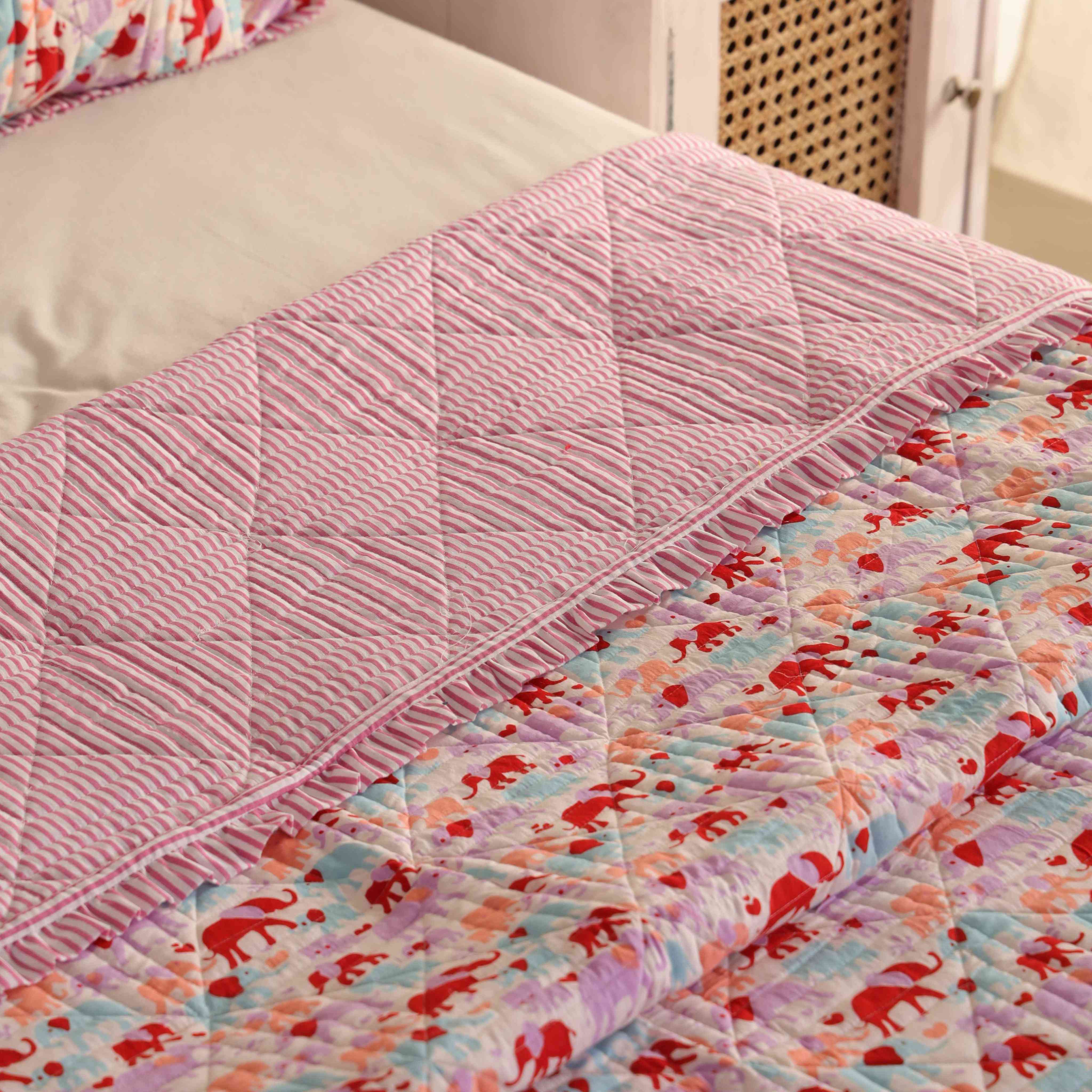 Two matching elephant print cotton pillow covers with striped ruffle accents.