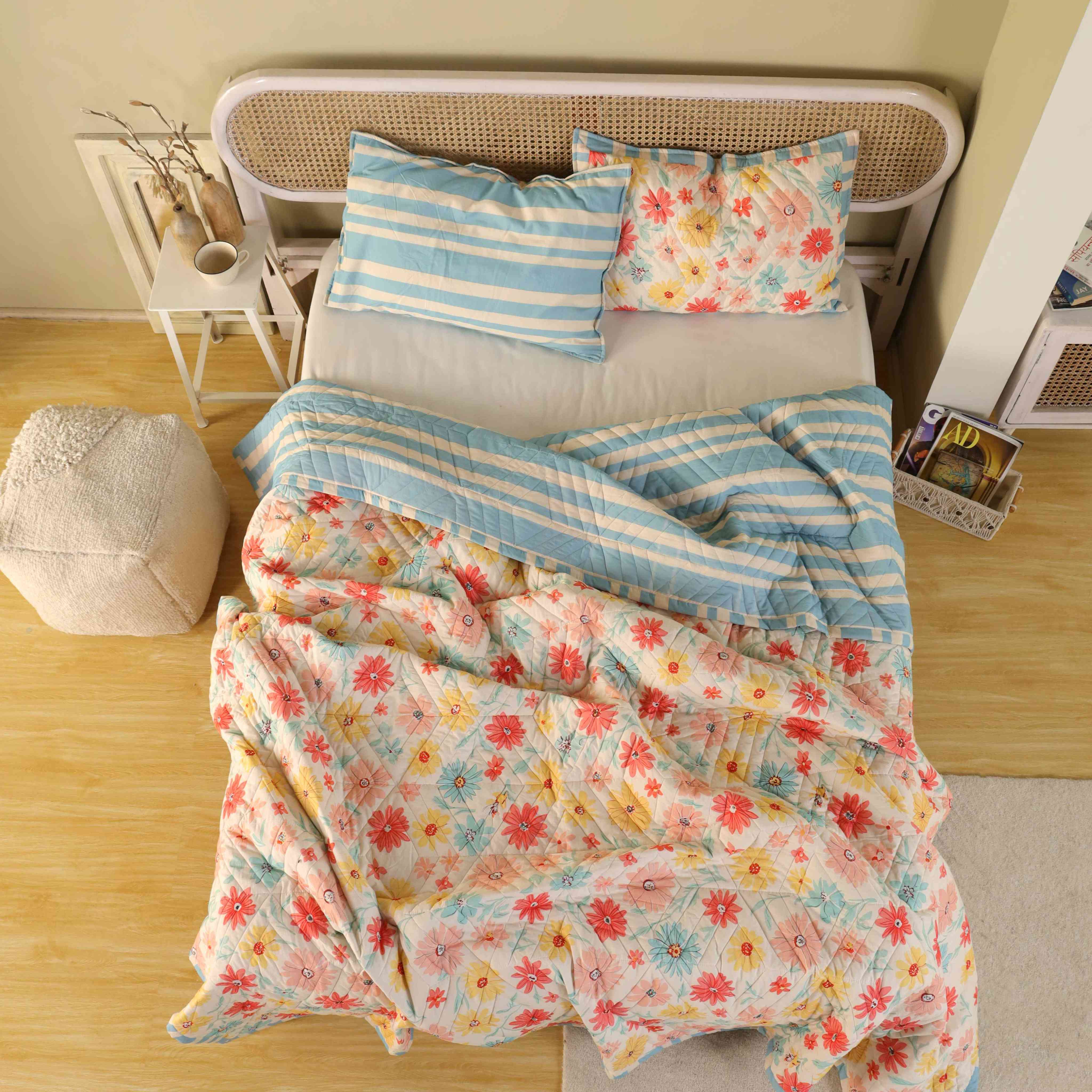 Two matching wildflower print cotton pillow covers with blue striped ruffled edges.