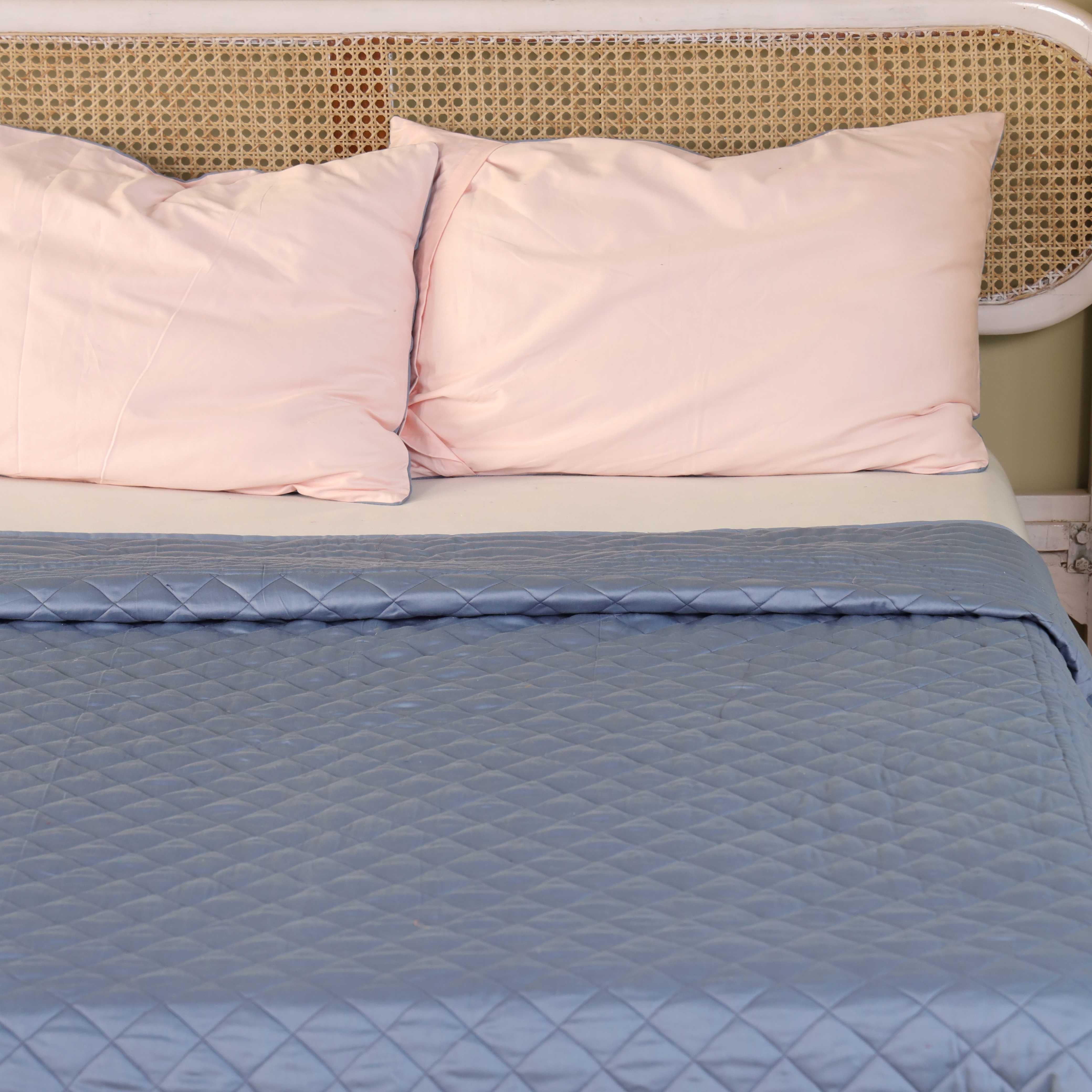 Close-up of the wave-patterned scalloped quilting on the blue satin fabric.