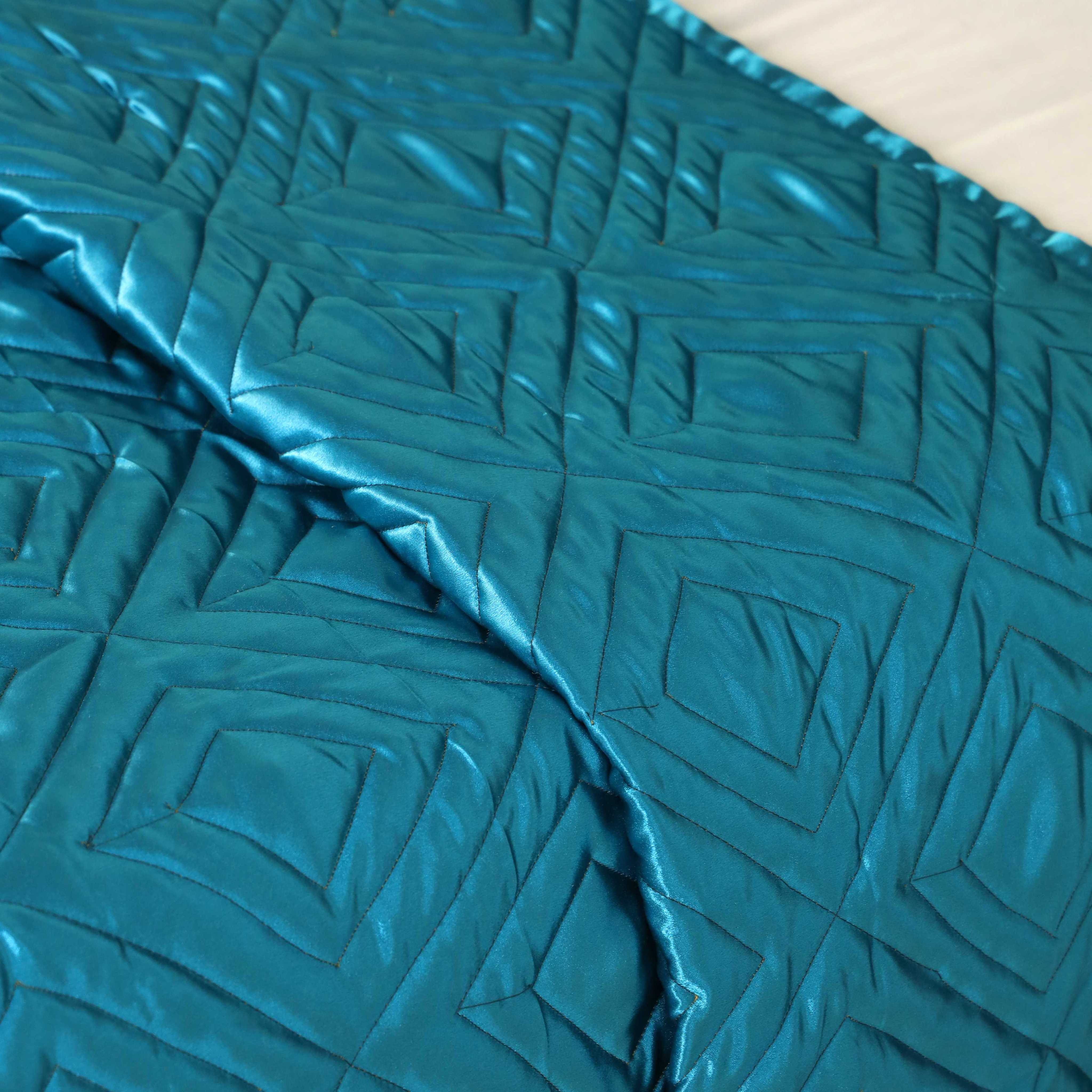 Matching teal blue satin pillow covers showing a high-shine silky finish