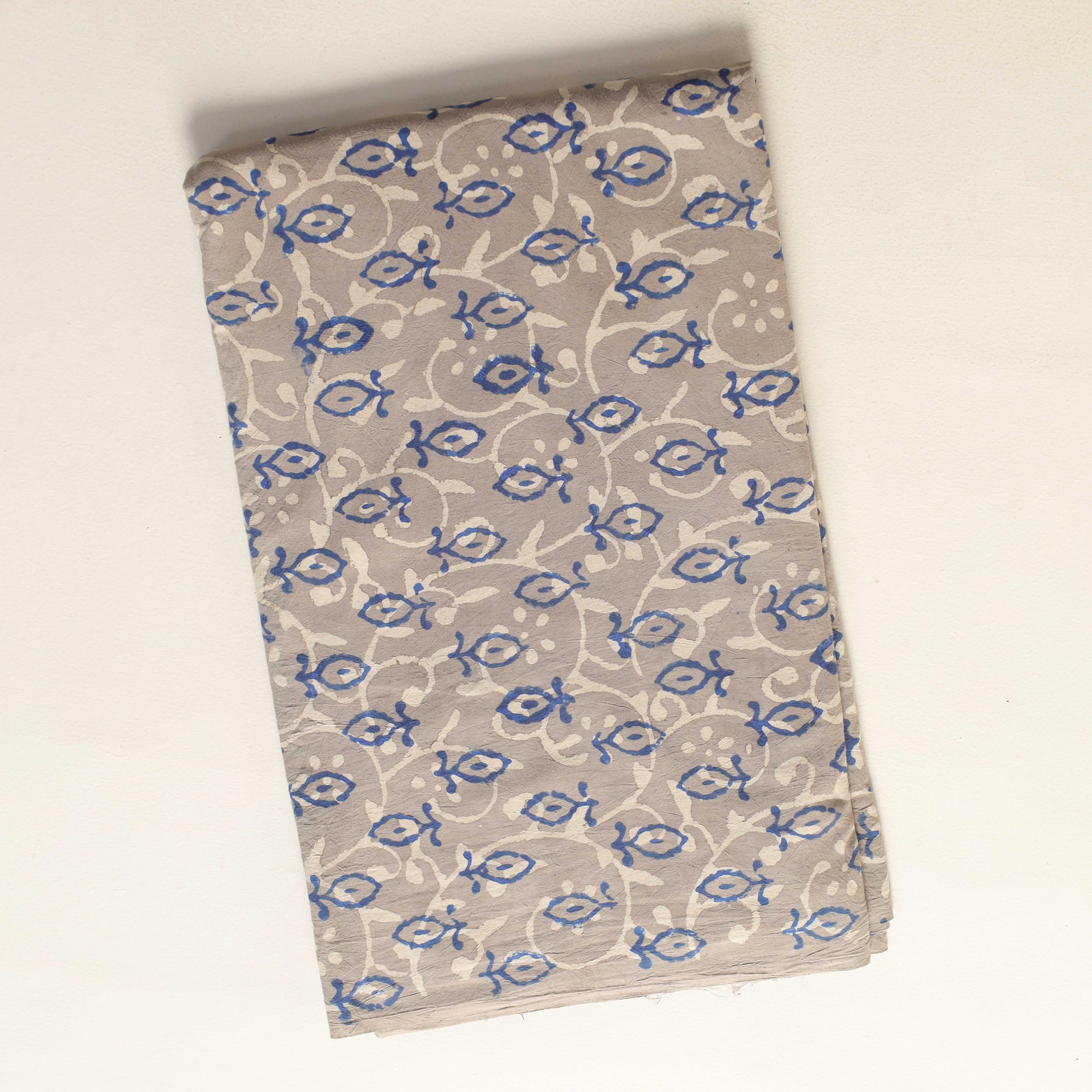 Folded fabric with blue and white pattern on a beige background