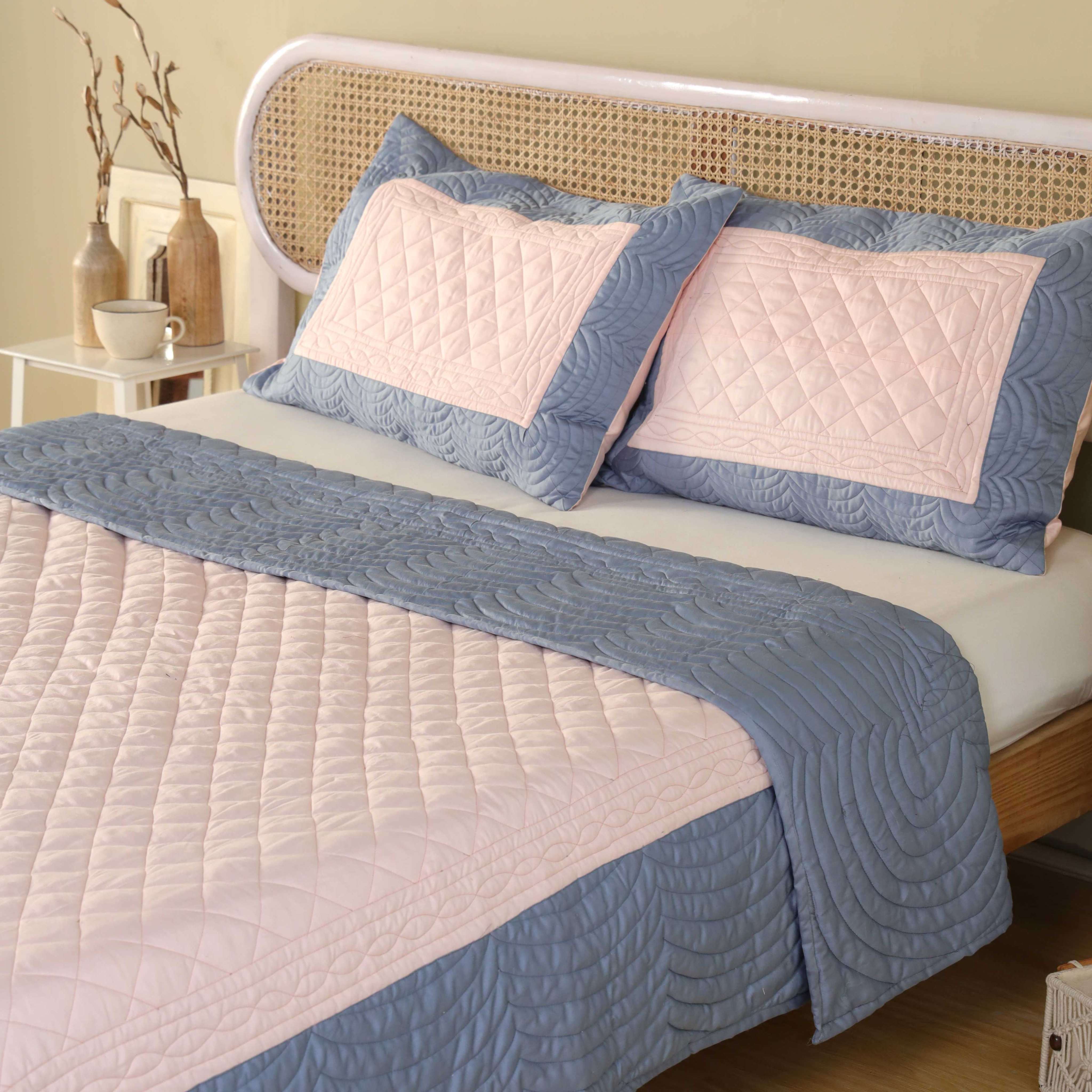 Close-up of the pink diamond quilting and blue scalloped quilting on satin fabric.