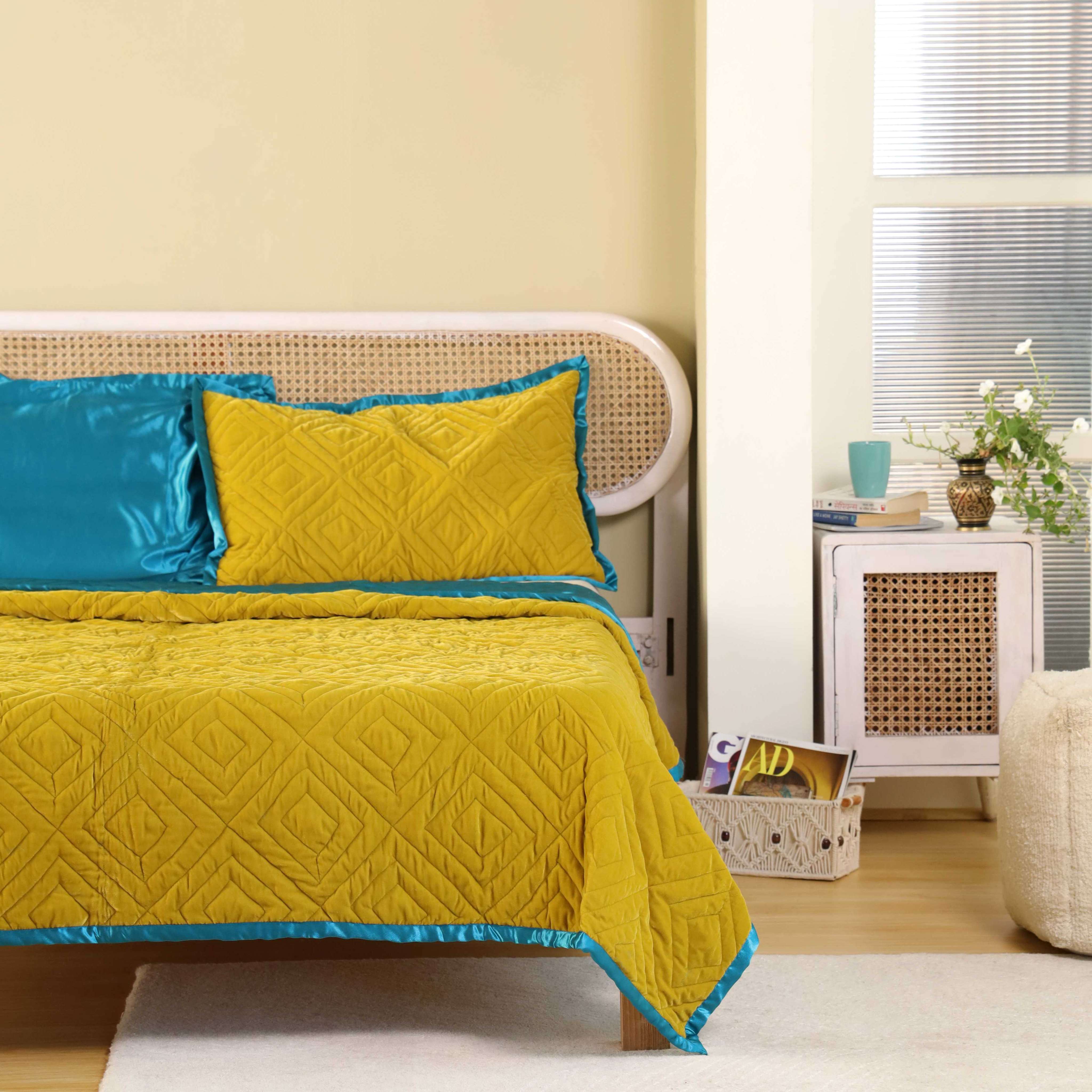 A modern boho-style bedroom featuring vibrant mustard and teal velvet bedding.