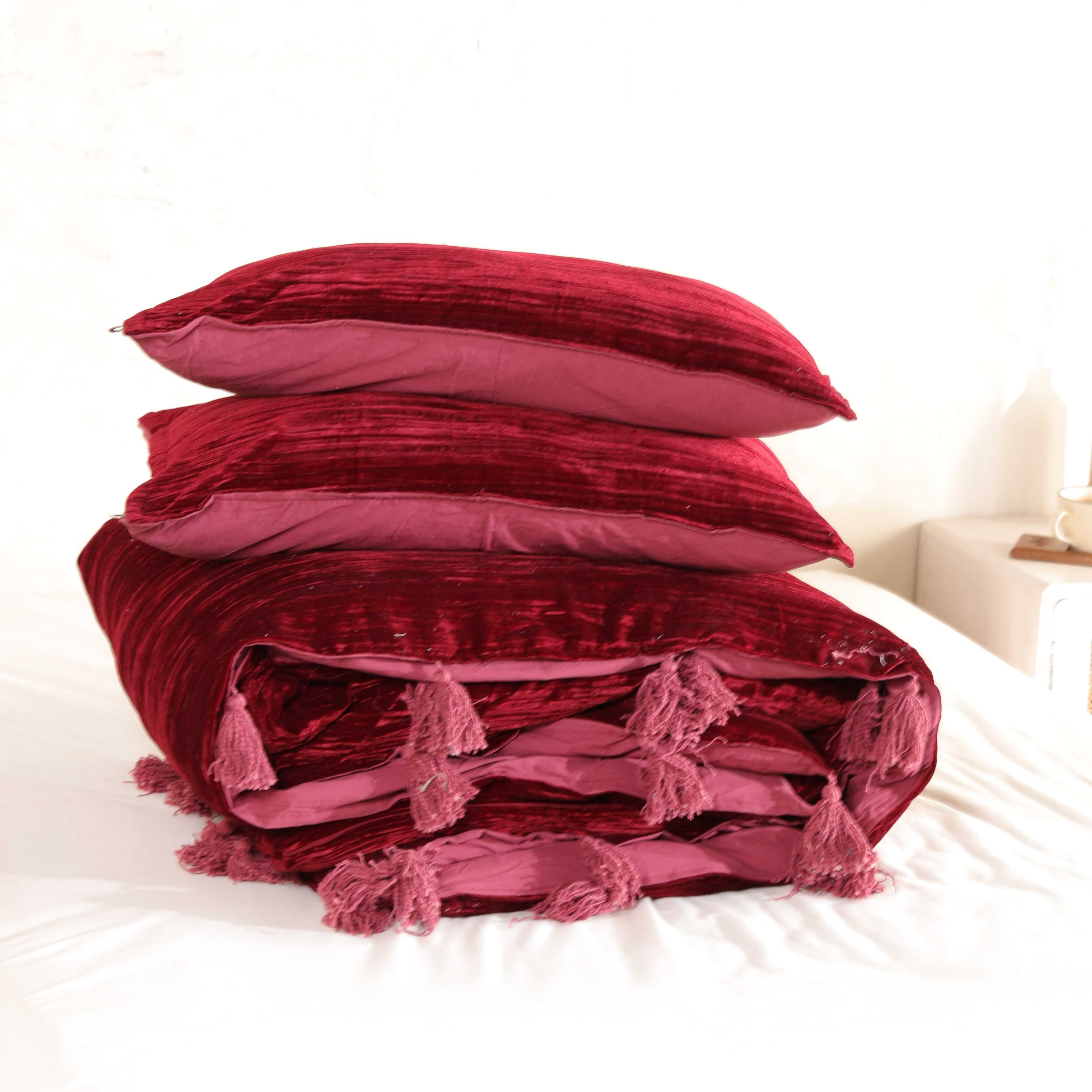 Lifestyle bedroom scene with burgundy bedding, a rattan nightstand, and a jute rug.