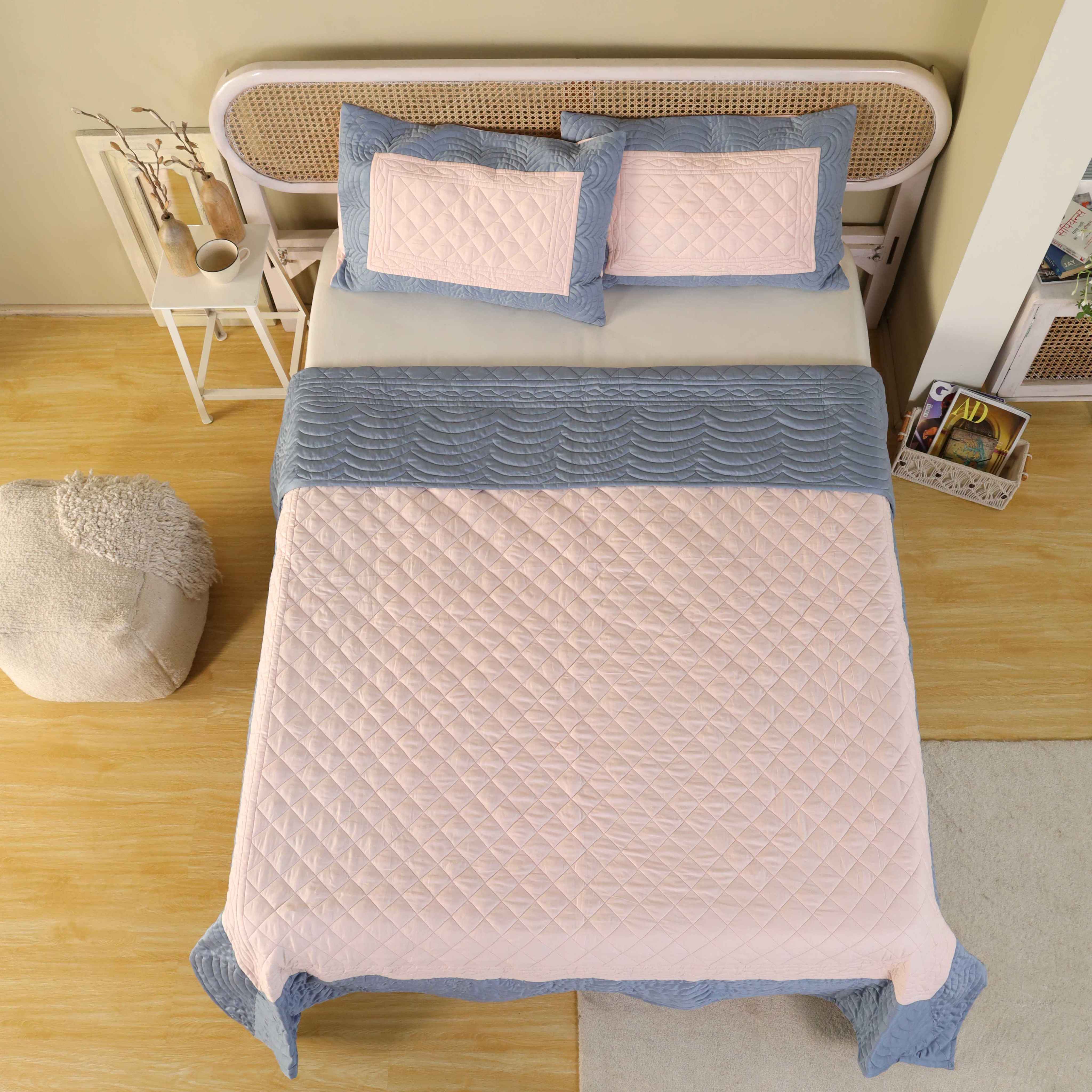 Two matching satin pillow covers with a pink quilted center and dusty blue border.