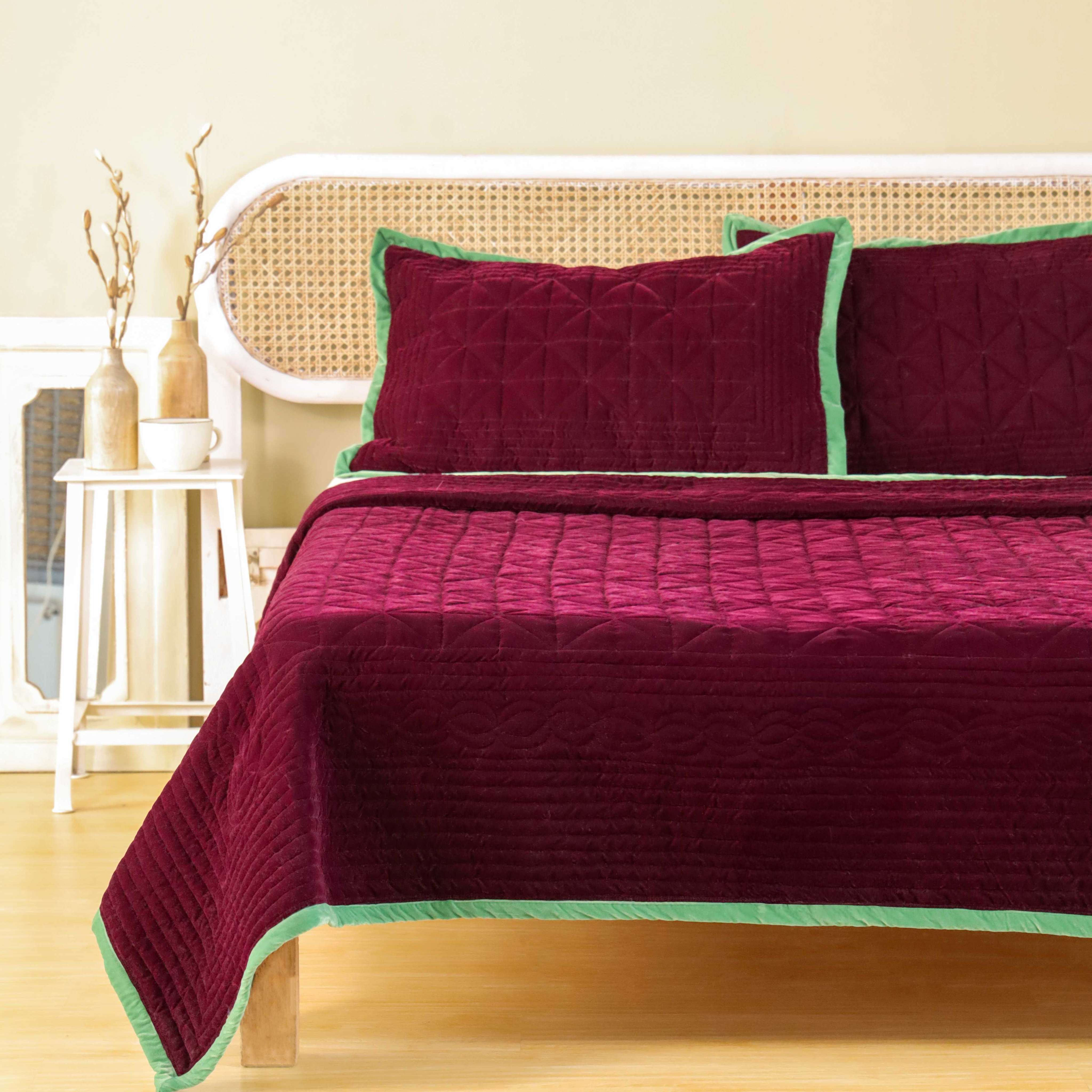 Detailed close-up of the diamond-stitch quilted texture on soft maroon velvet fabric.
