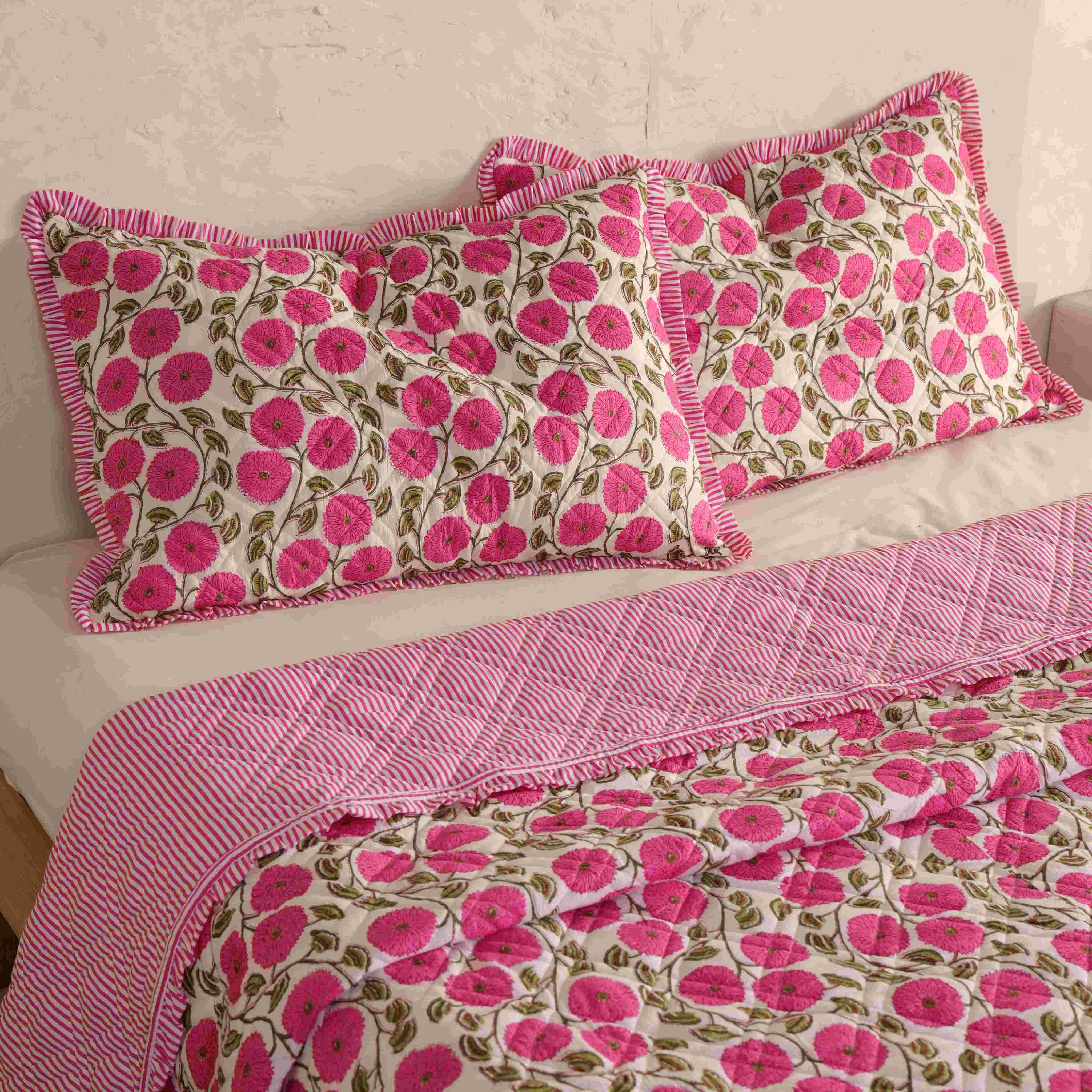 Close-up of the striped ruffle trim and pink floral print on a cotton quilt.
