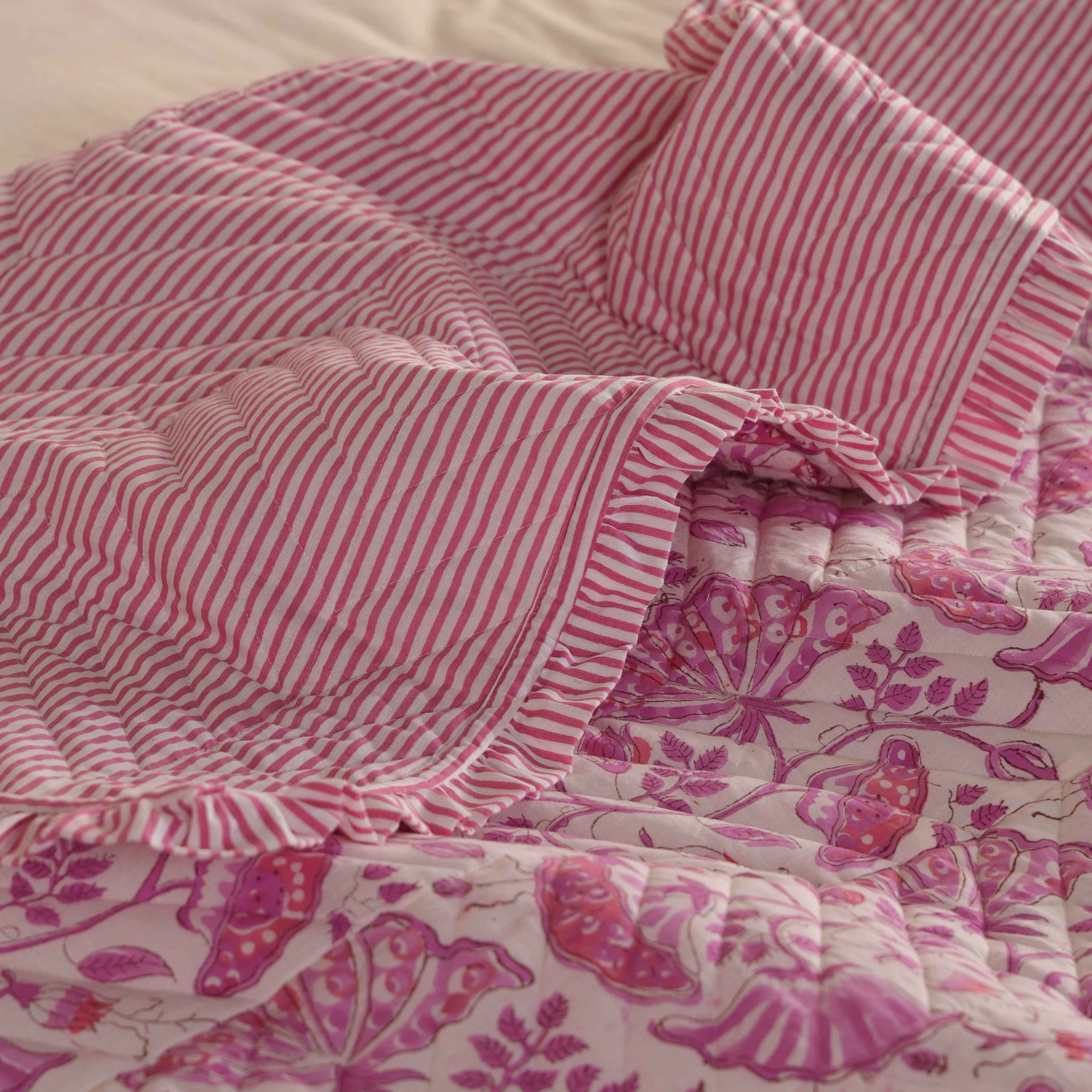 Neatly folded pink floral velvet quilt set showing the plush texture.