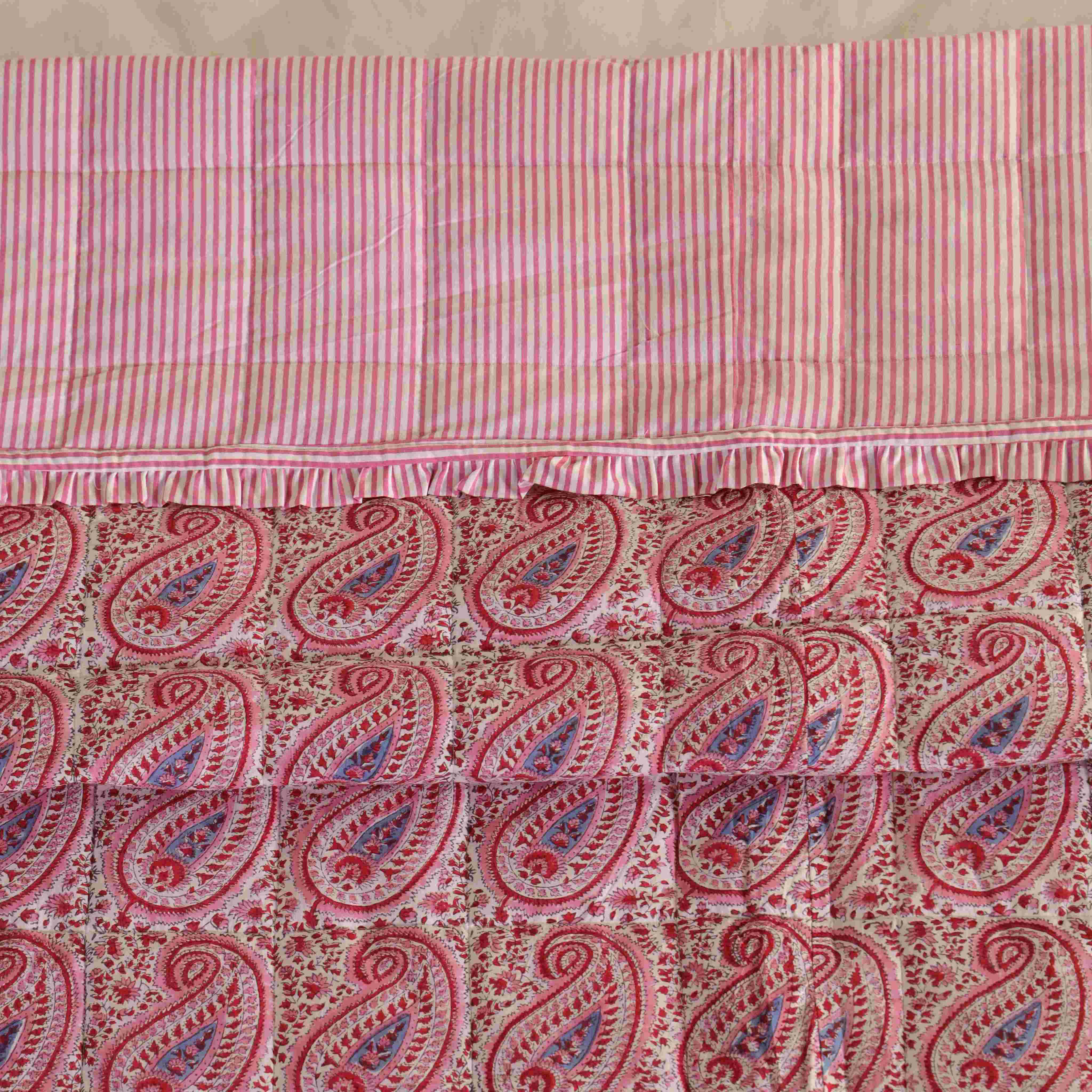 A neatly folded pink cotton quilt set showing the soft texture and vibrant patterns.