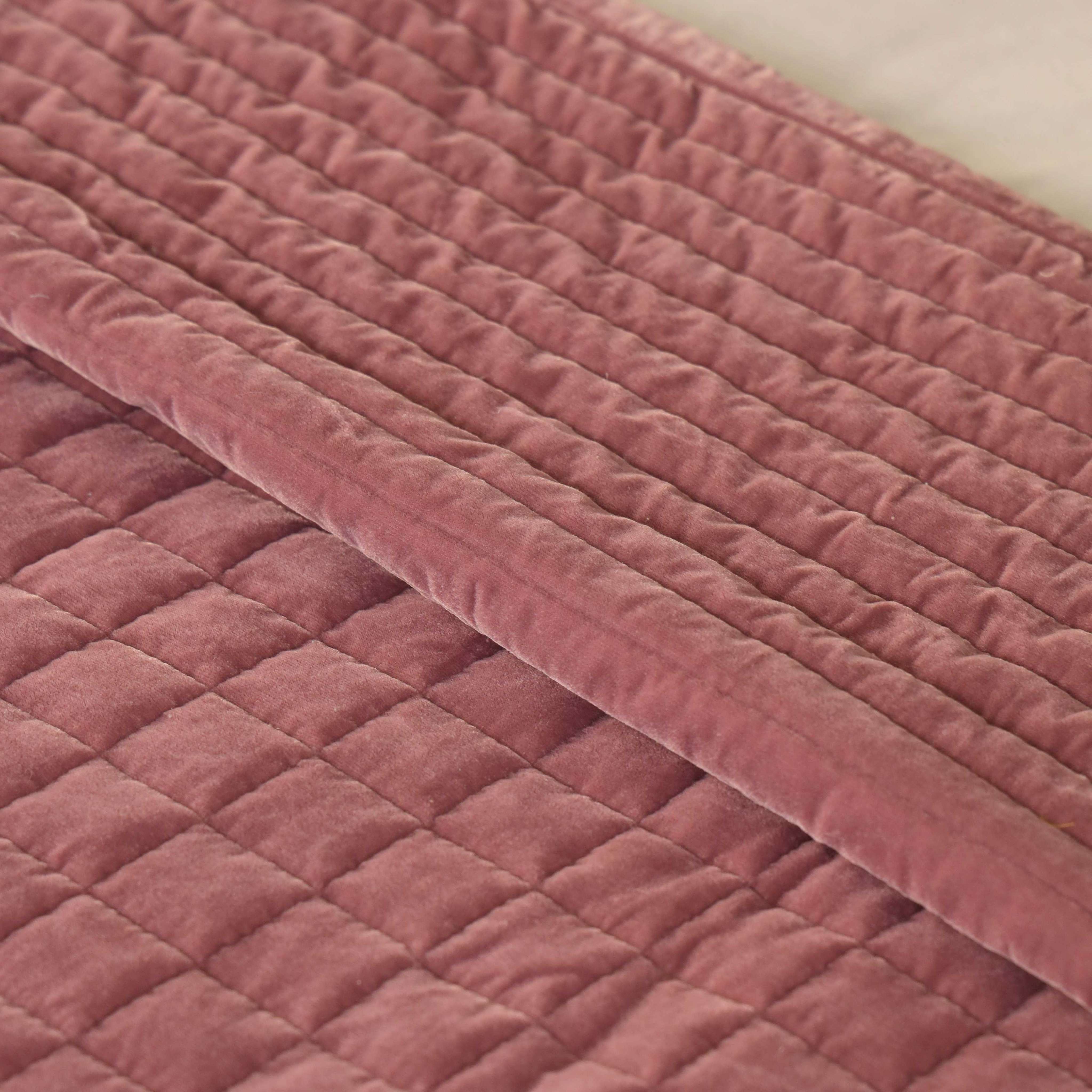 Close-up detail of the horizontal channel stitching on soft dusty pink velvet fabric.