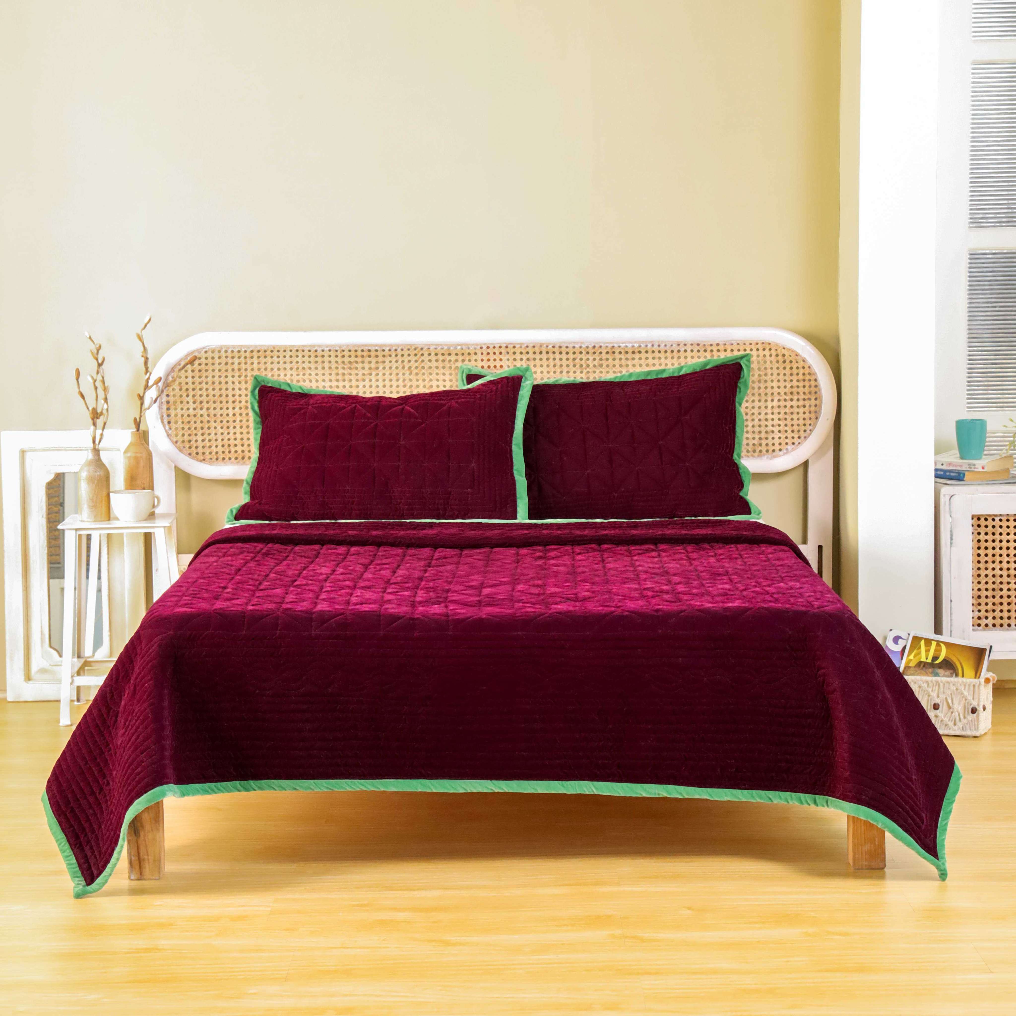 Luxury maroon quilted bedding set styled in a bright minimalist bedroom with natural wood accents.