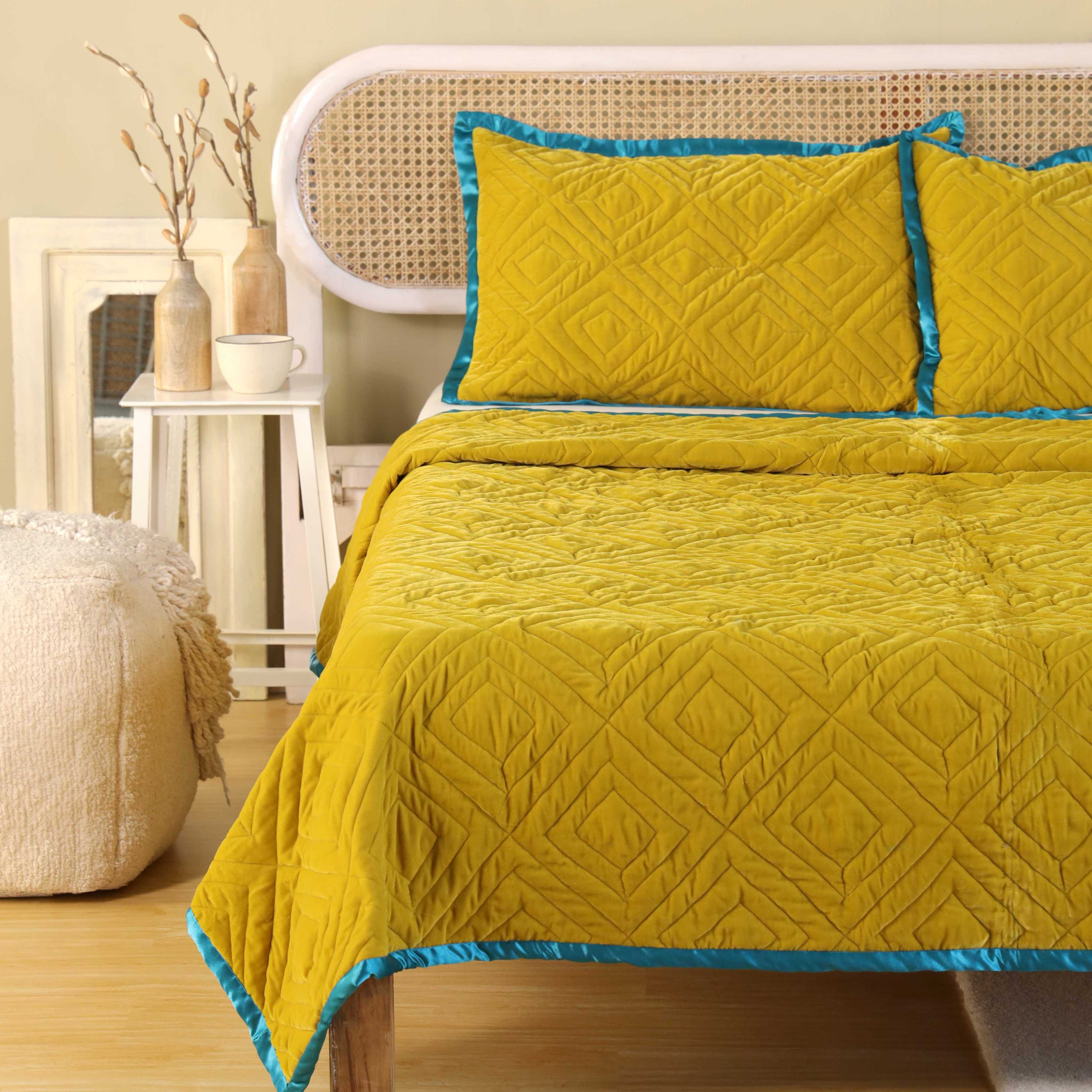 Full view of a luxury mustard yellow satin bedding set in a bright, modern minimalist bedroom.