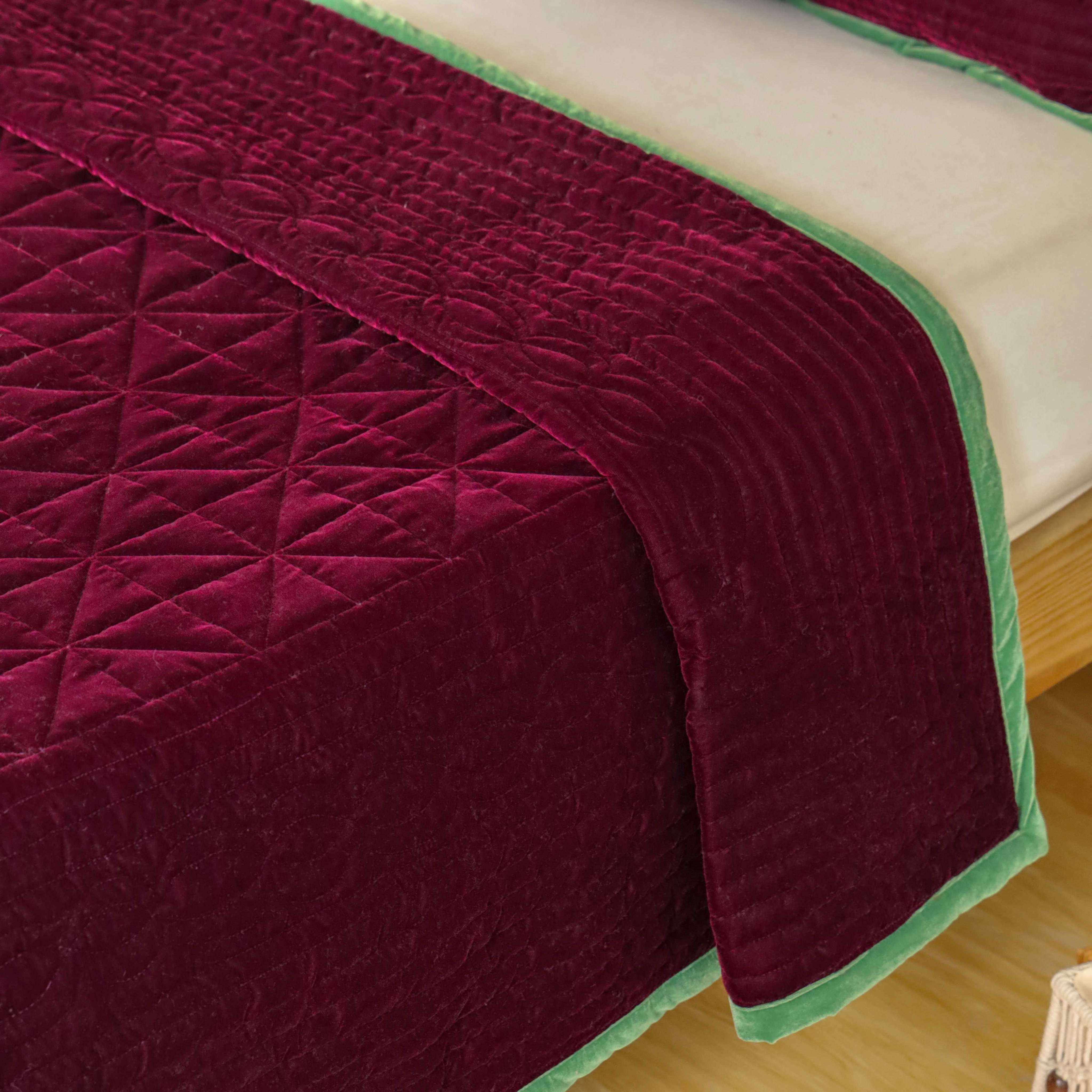 High-angle lifestyle shot of a cozy bedroom featuring a maroon and green velvet duvet set.