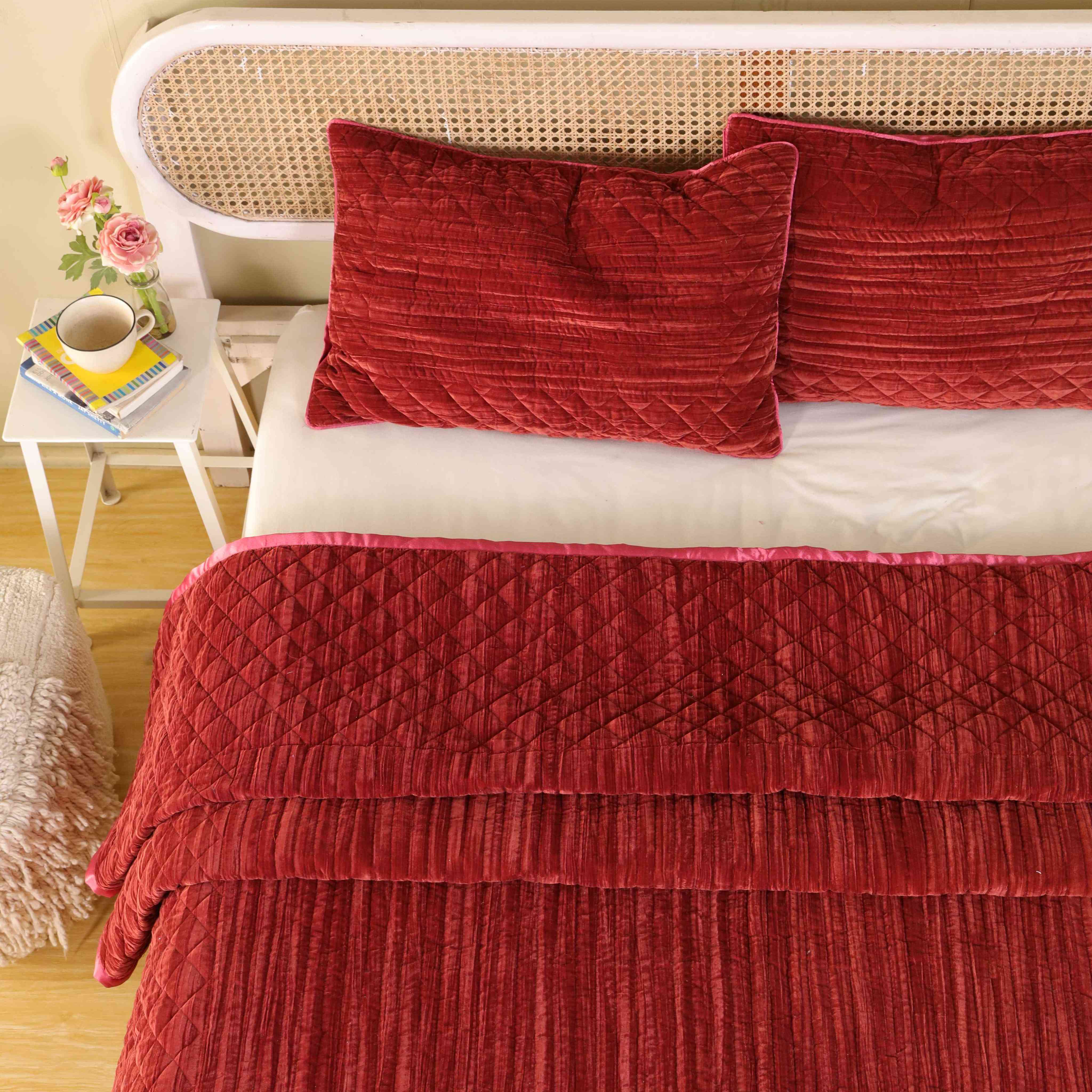 Luxury red velvet bedding featuring a mix of diamond and vertical channel quilting patterns.