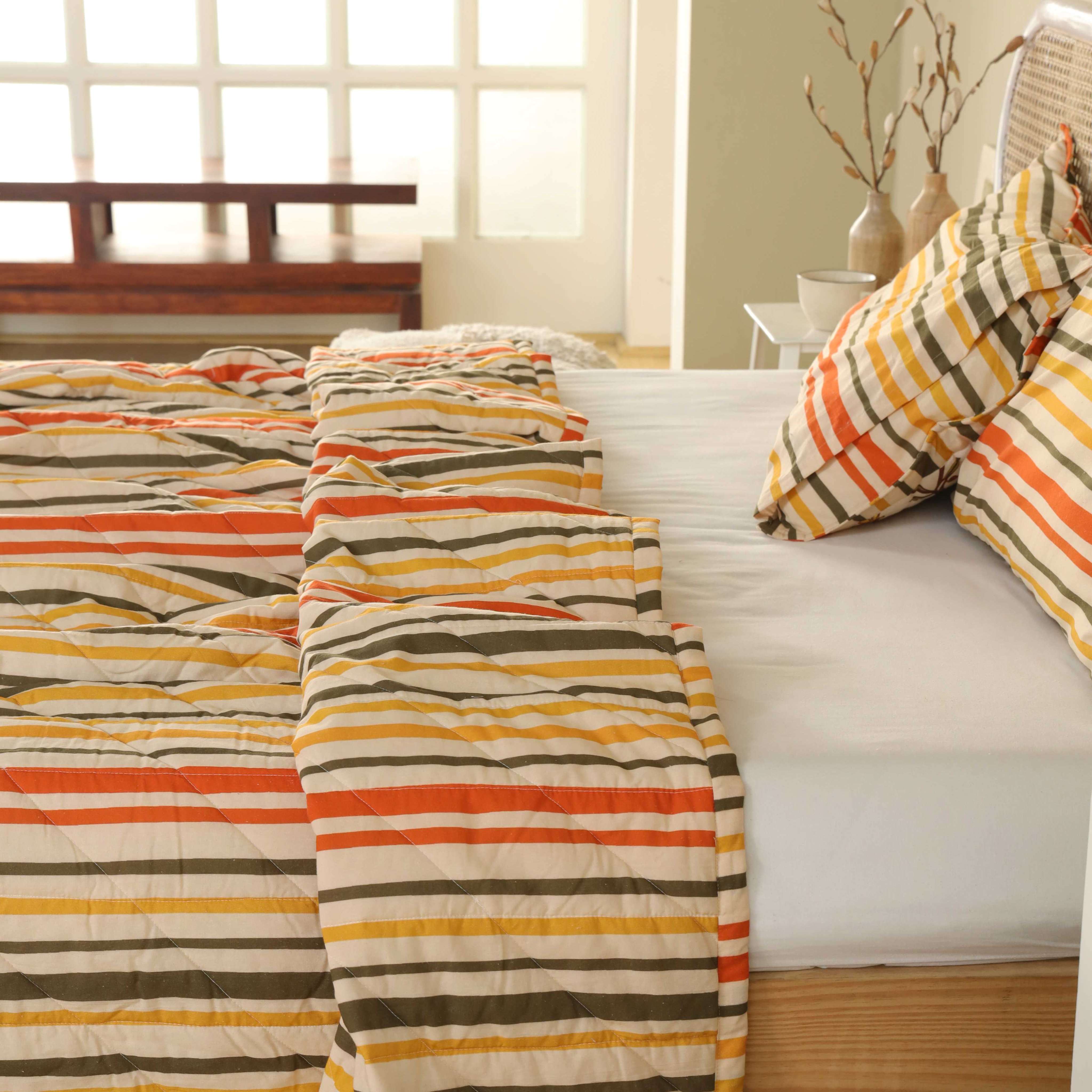 Modern southwestern bedroom interior featuring a striped multi-color cotton quilt and wood accents.