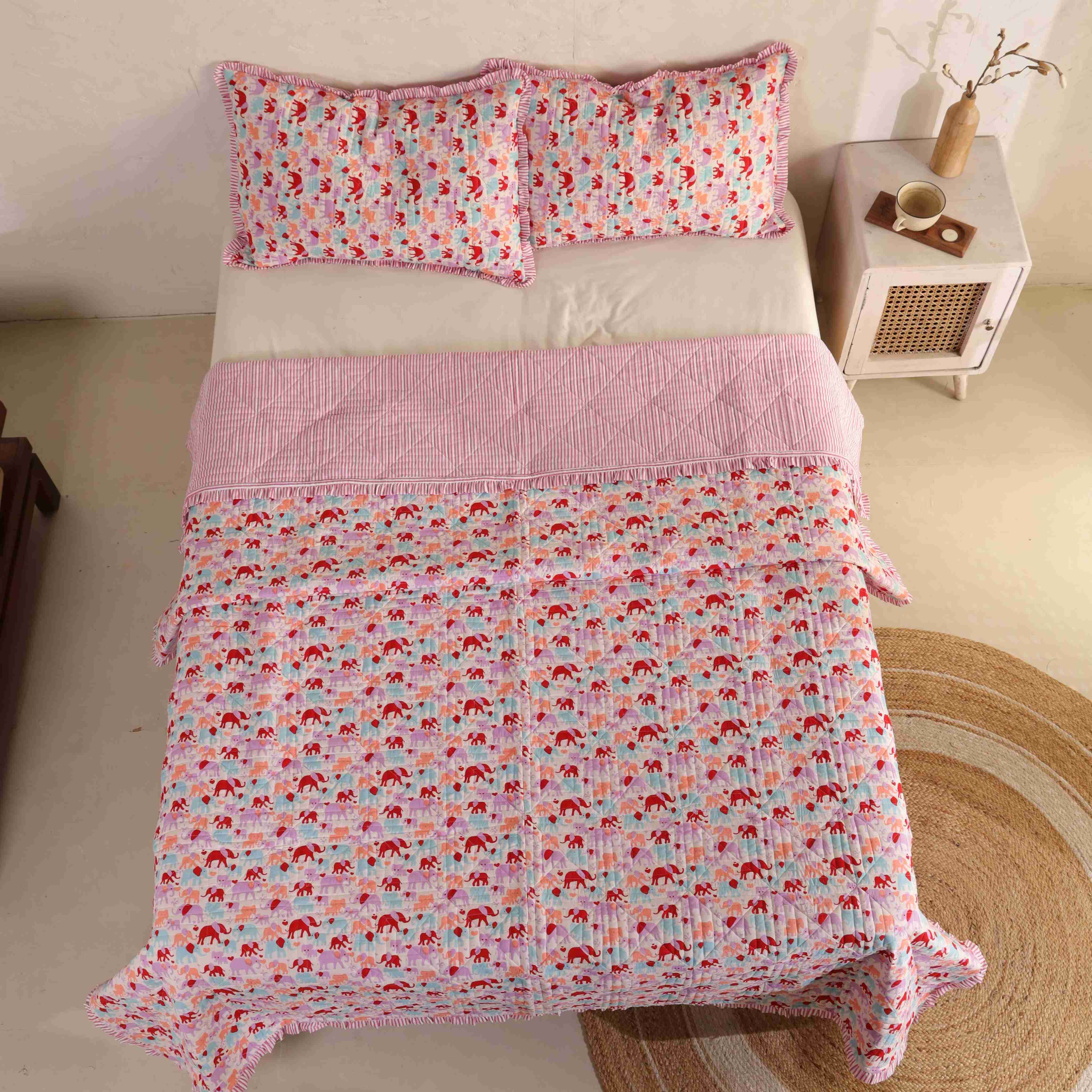 Whimsical bedroom interior featuring a colorful elephant print cotton quilt.