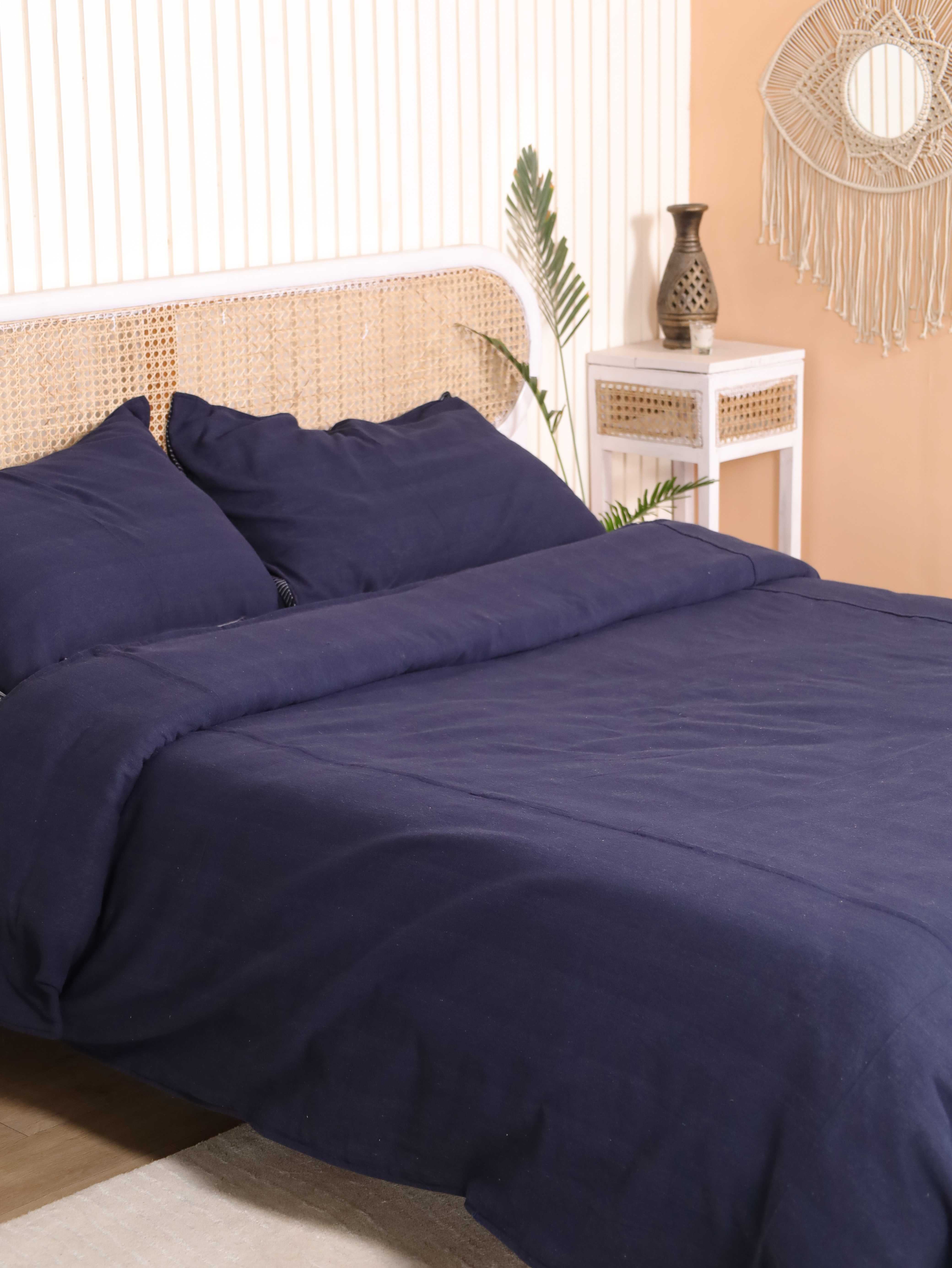 A deep navy blue cotton duvet cover neatly folded, highlighting the consistent, vibrant indigo pigment.