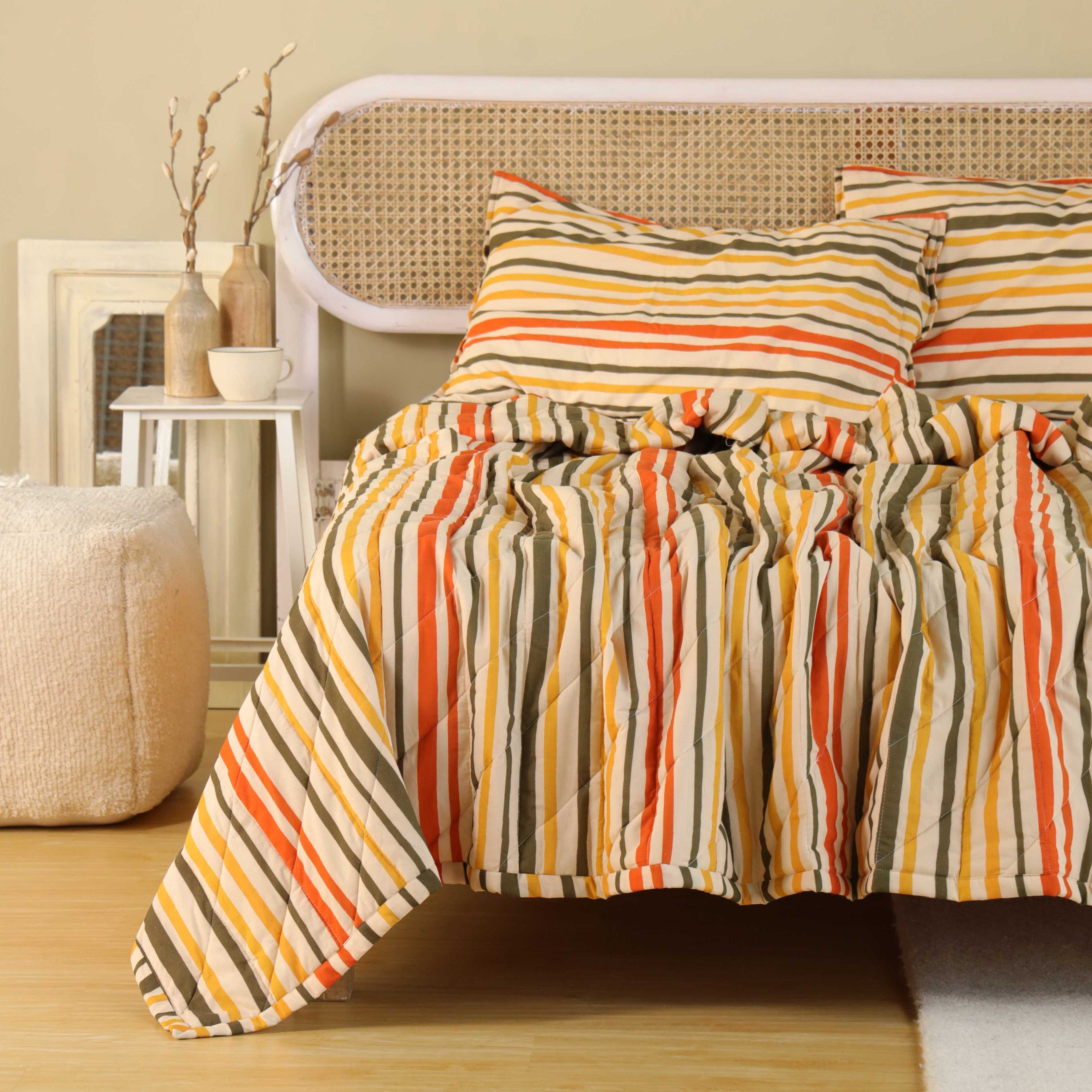 Two matching multi-color striped cotton pillow covers resting on a white bed sheet.