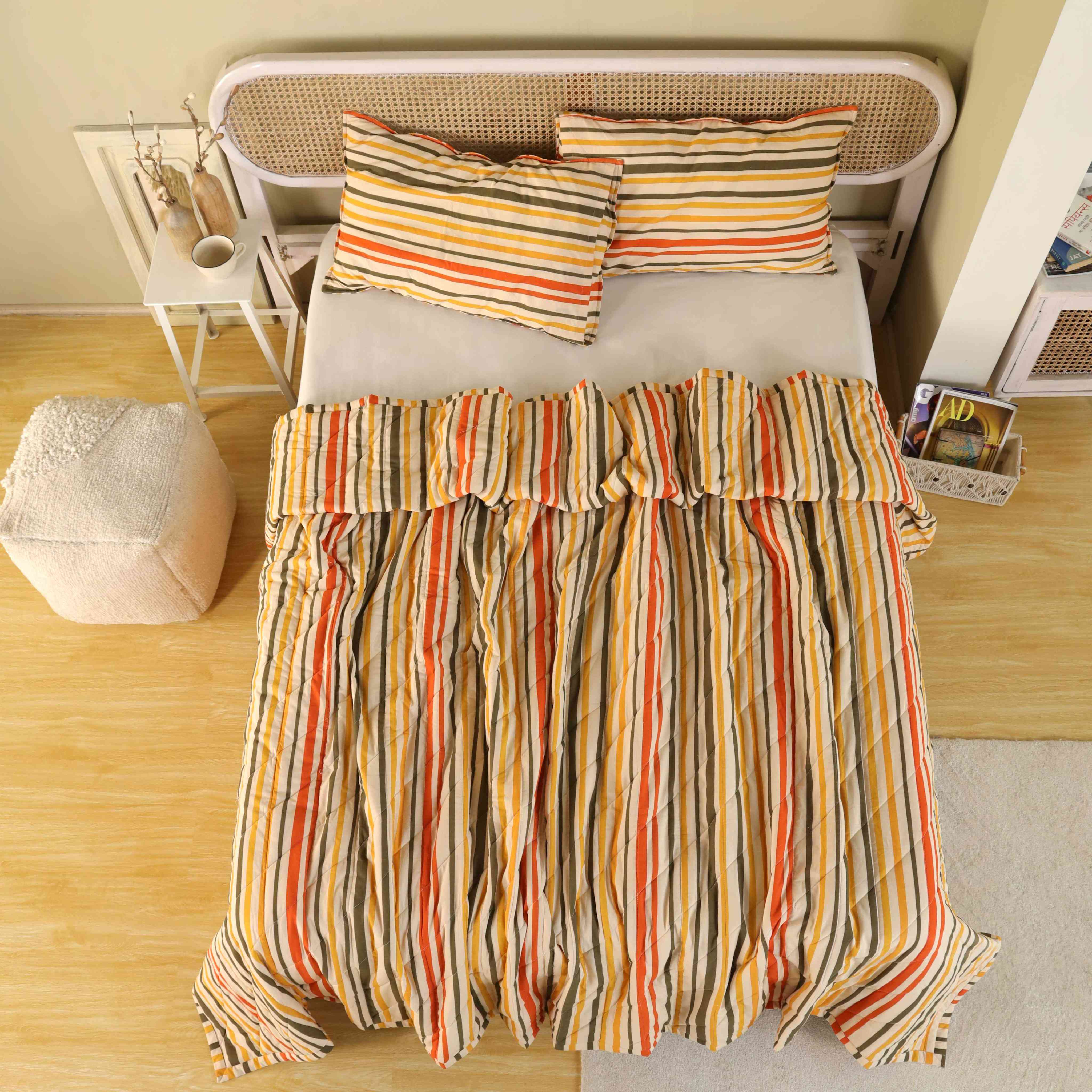 3-piece sunset stripe multi-color cotton quilt set on a bed in a modern boho room.