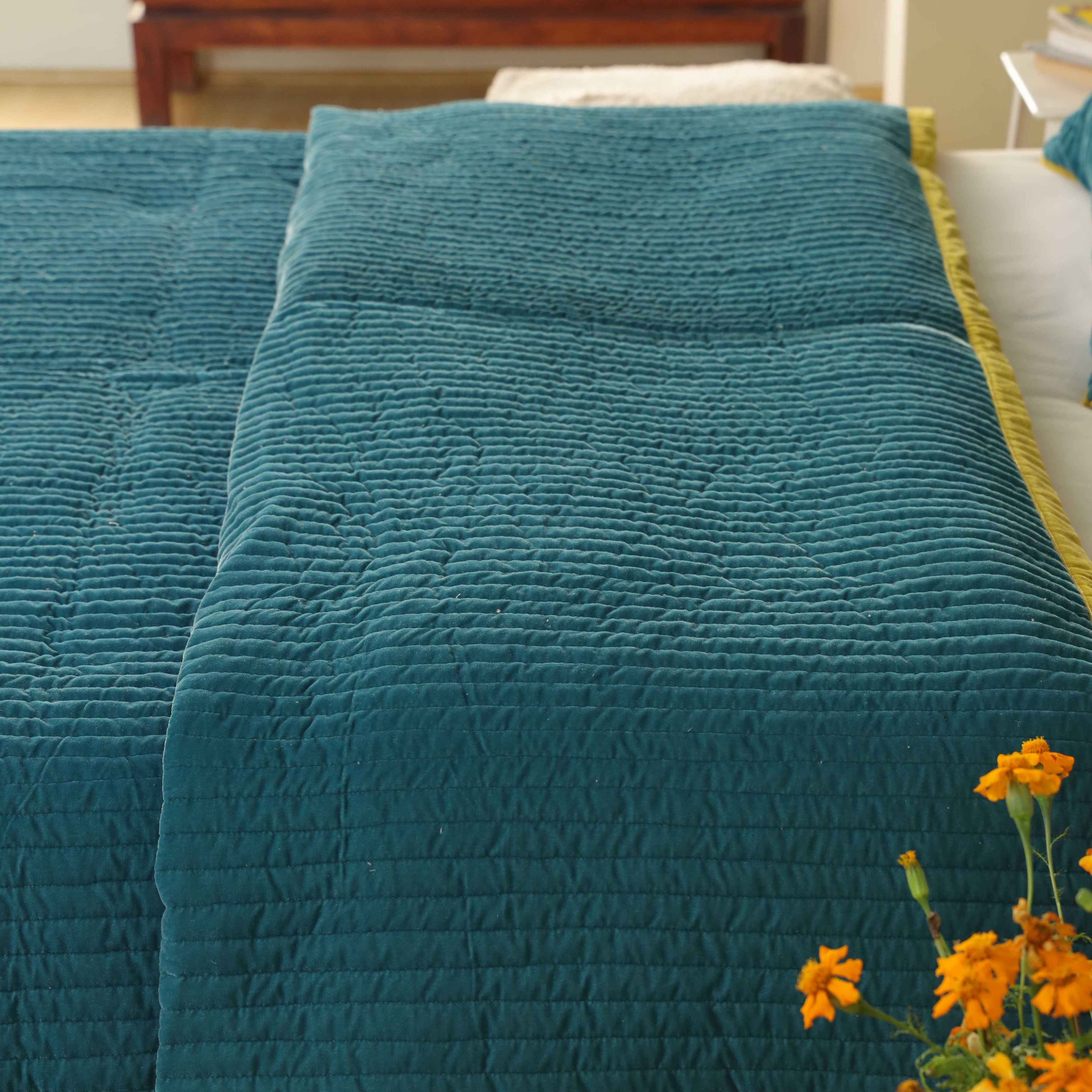 Detailed view of soft teal velvet fabric and modern vertical quilted lines on a luxury duvet.
