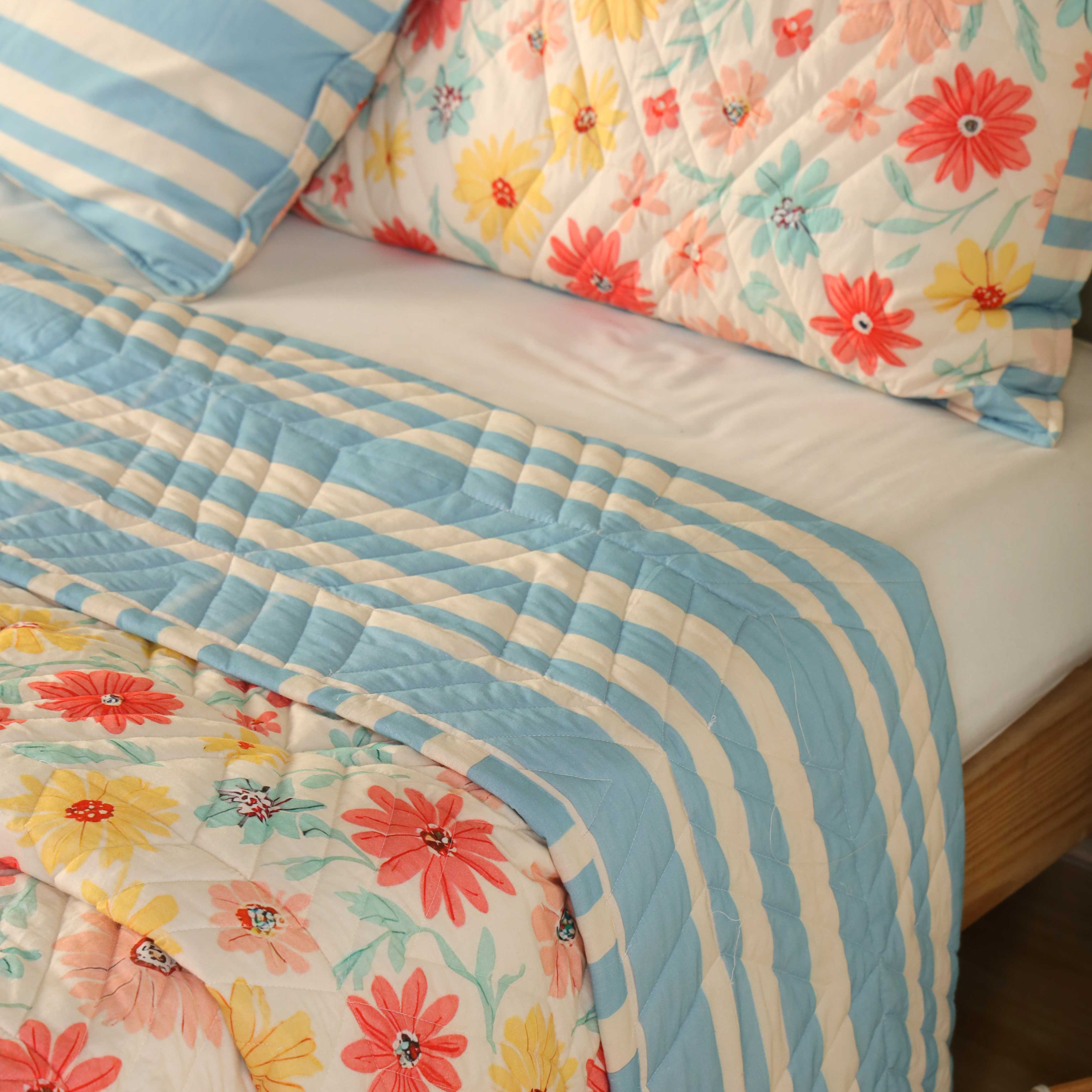 Close-up of coral and teal wildflower print on a breathable cotton quilt.